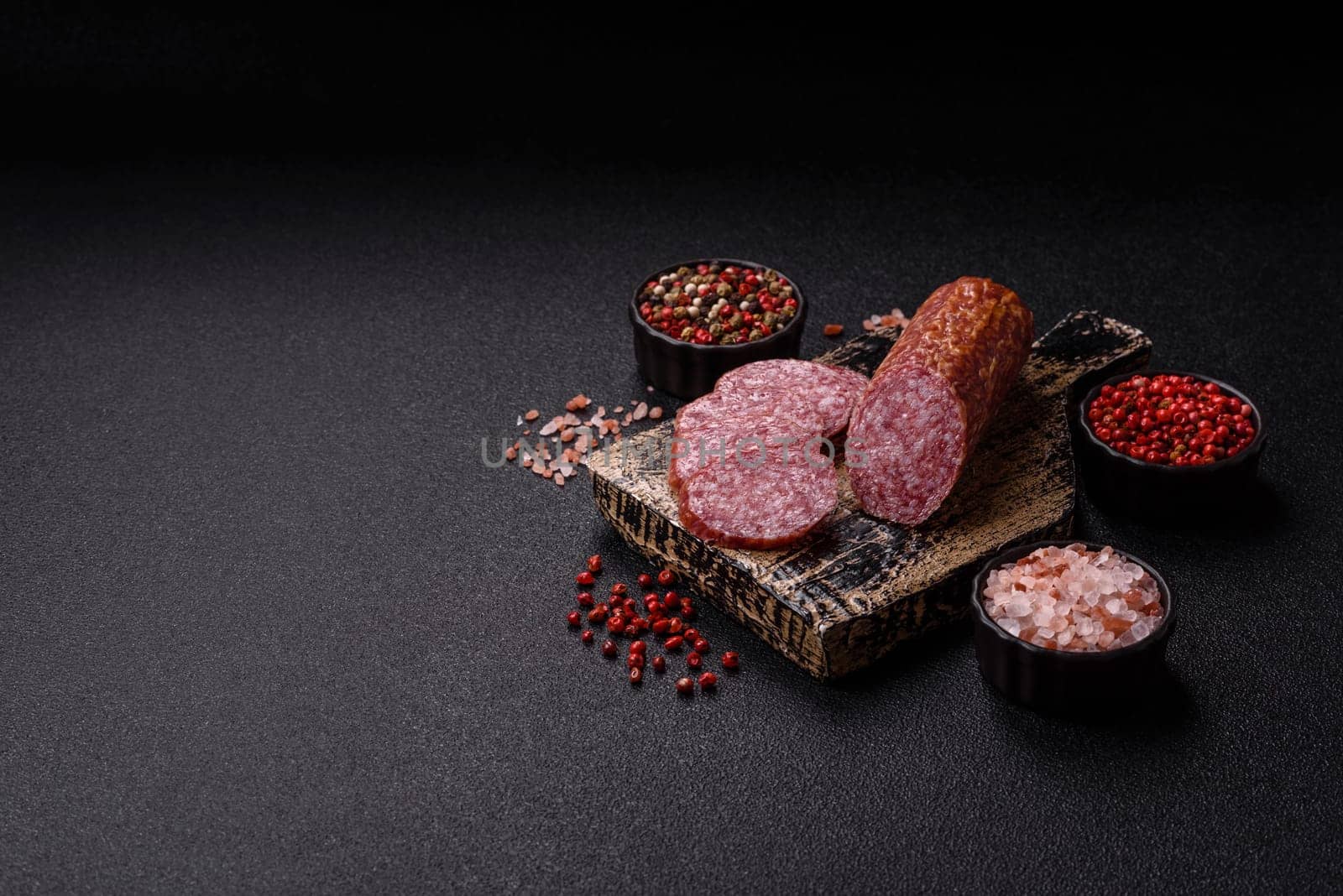 Sliced salami sausage, smoked meat, delicious deli snacks on a plate