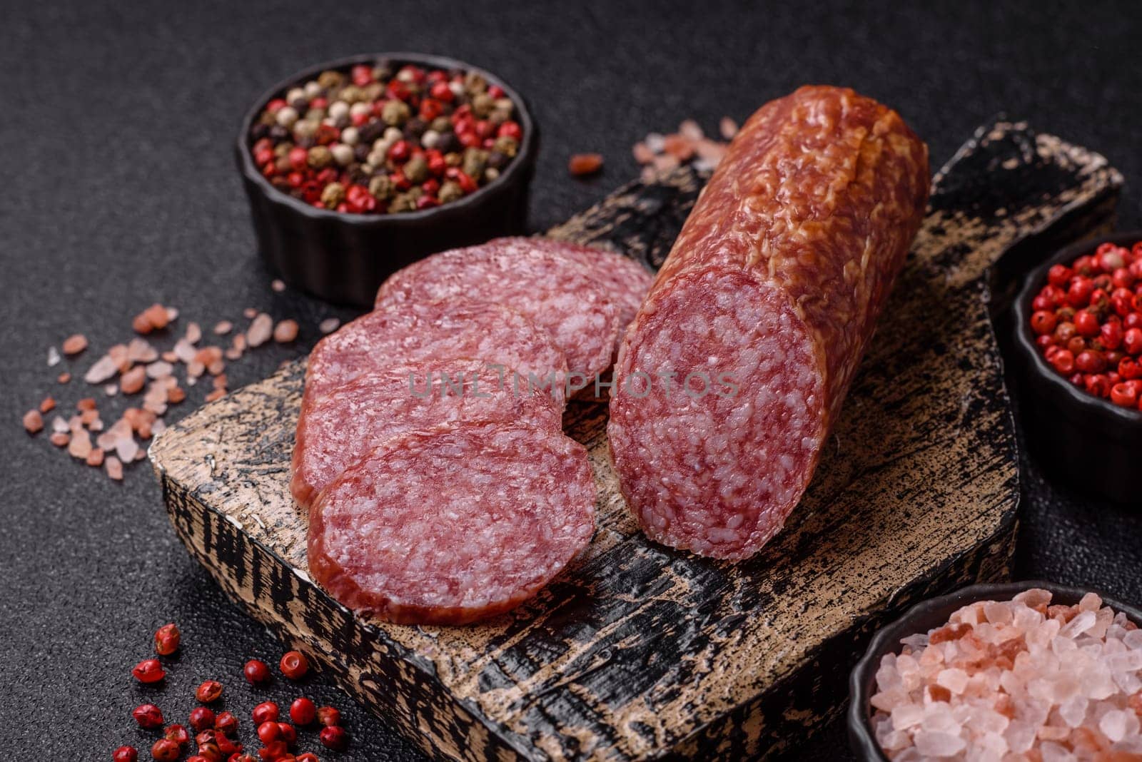 Sliced salami sausage, smoked meat, delicious deli snacks on a plate