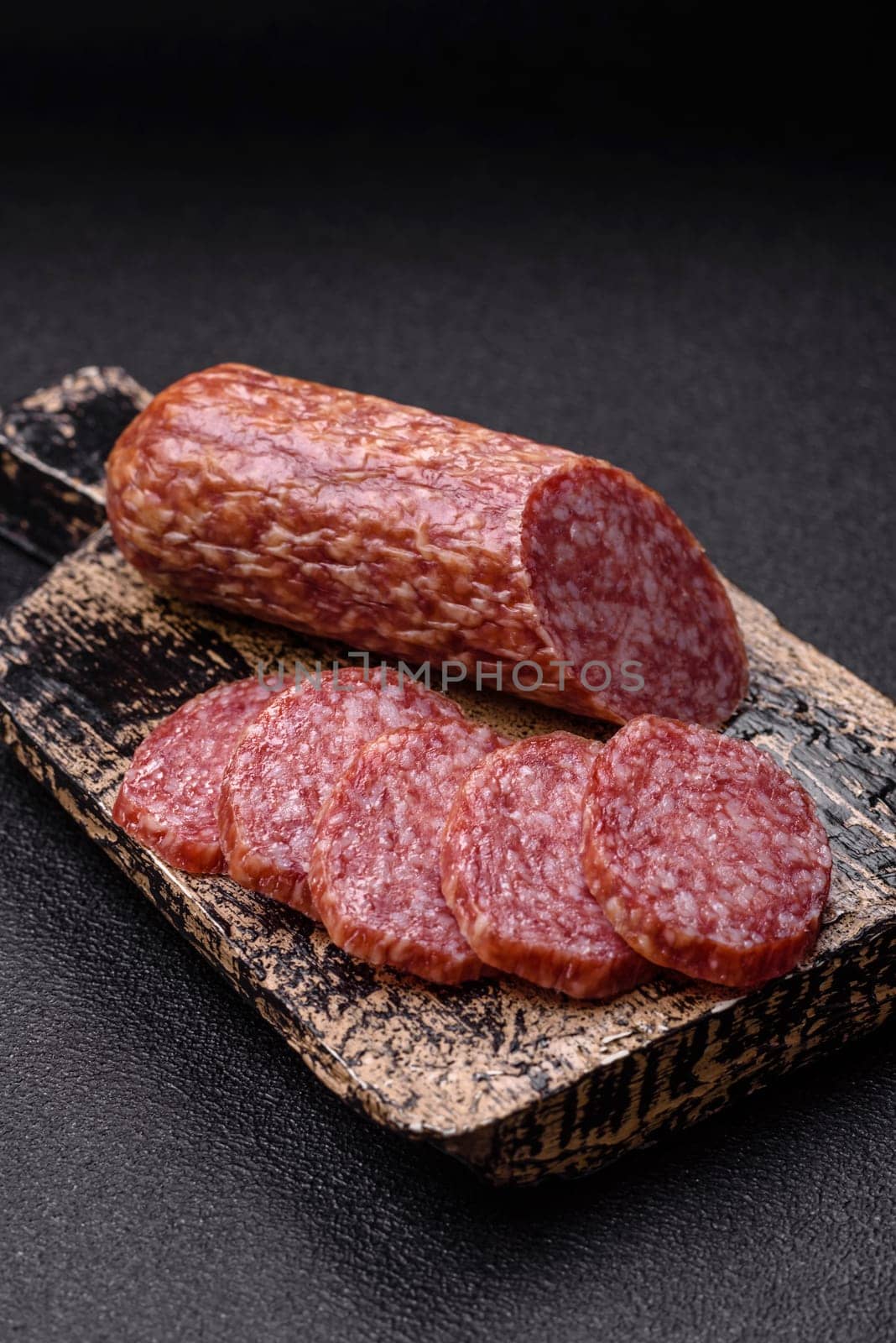 Sliced salami sausage, smoked meat, delicious deli snacks on a plate