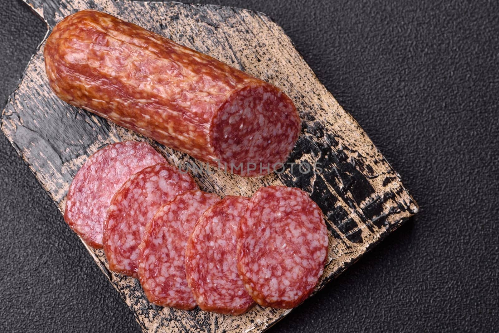 Sliced salami sausage, smoked meat, delicious deli snacks on a plate