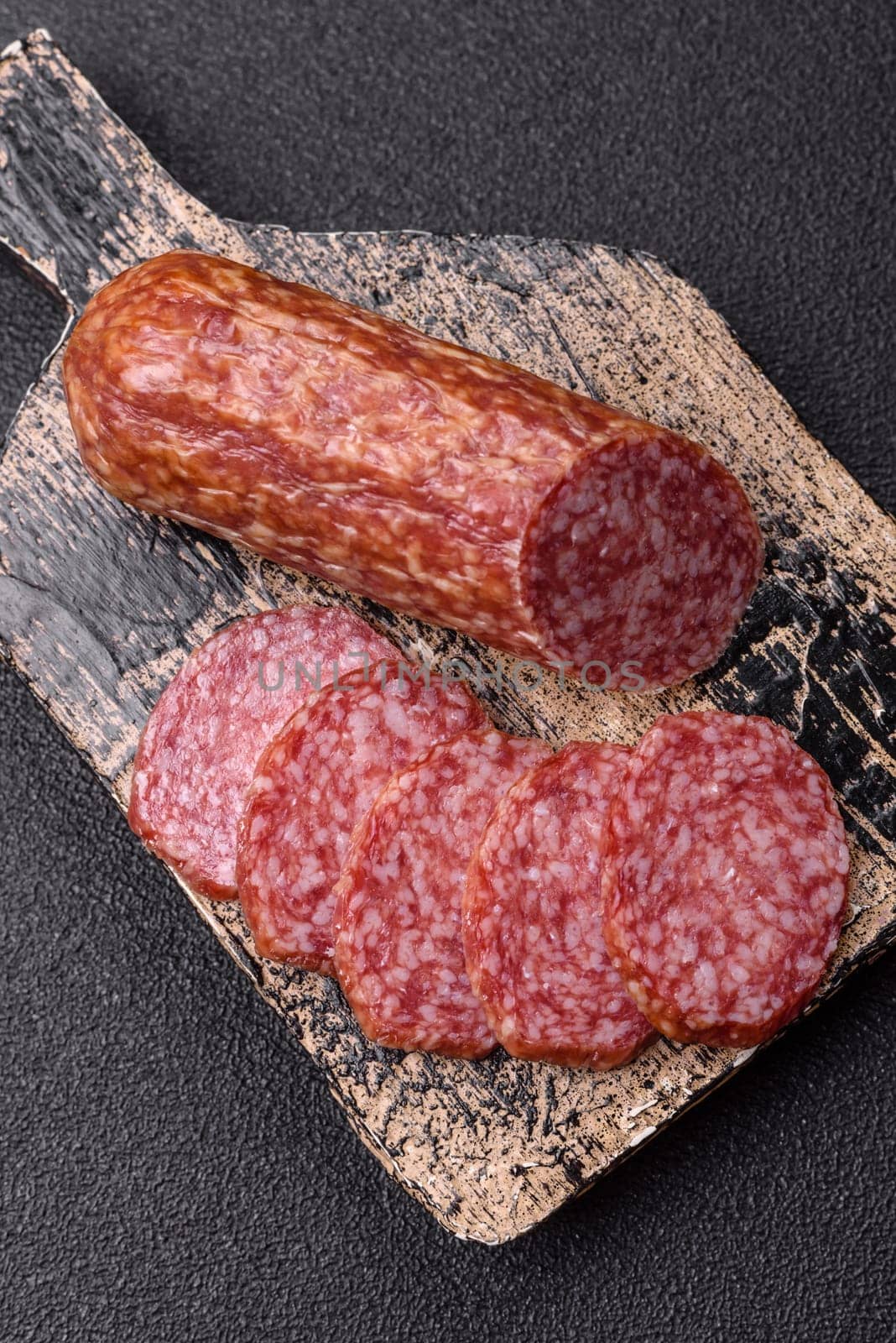 Sliced salami sausage, smoked meat, delicious deli snacks on a plate