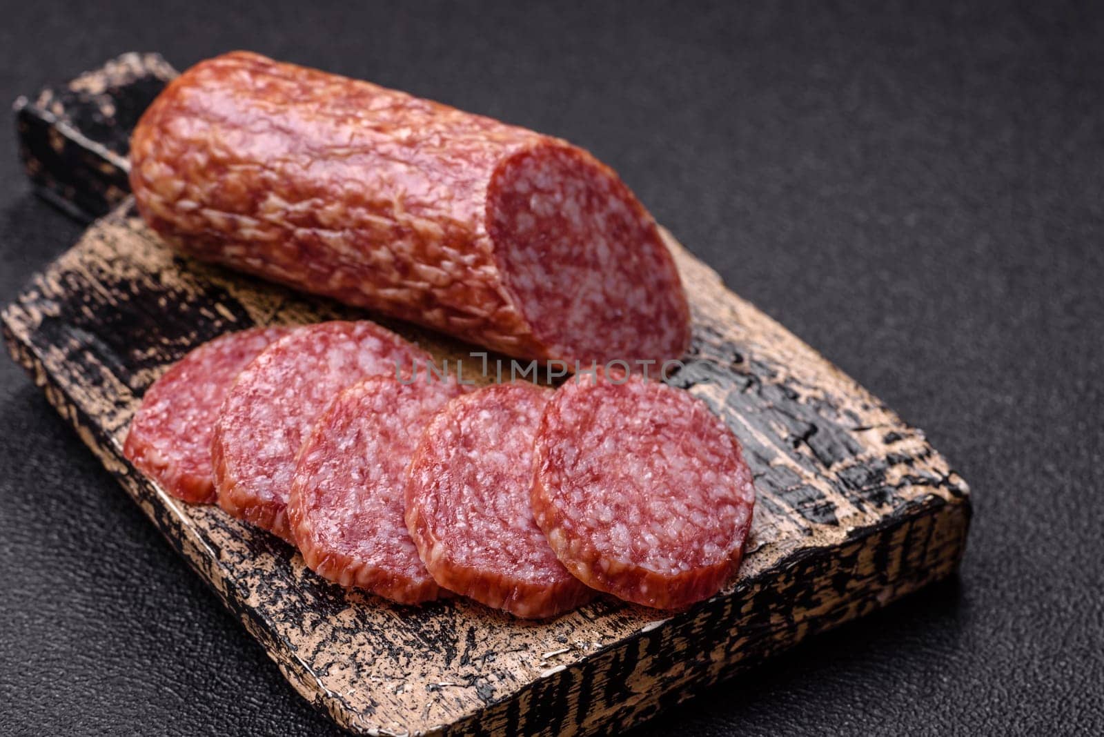 Sliced salami sausage, smoked meat, delicious deli snacks on a plate