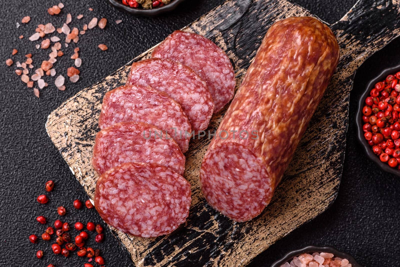 Sliced salami sausage, smoked meat, delicious deli snacks on a plate