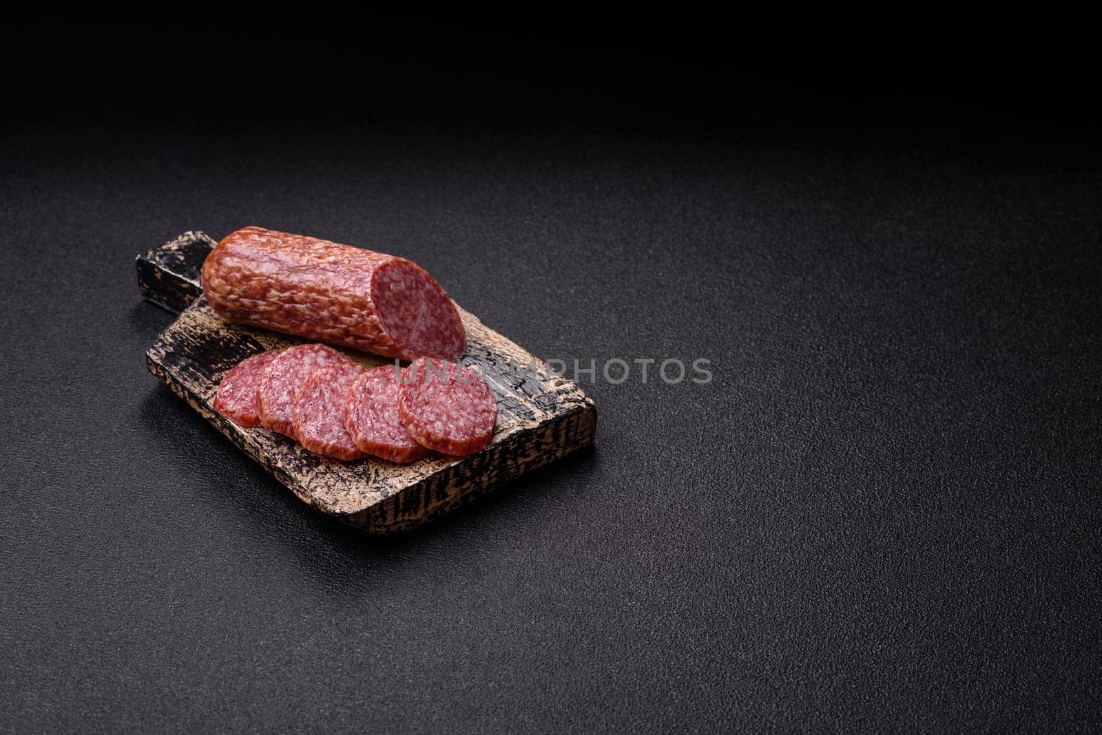 Sliced salami sausage, smoked meat, delicious deli snacks on a plate
