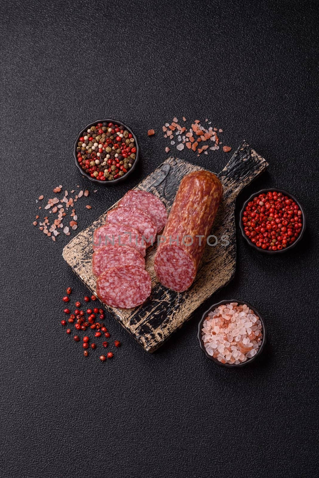 Sliced salami sausage, smoked meat, delicious deli snacks on a plate