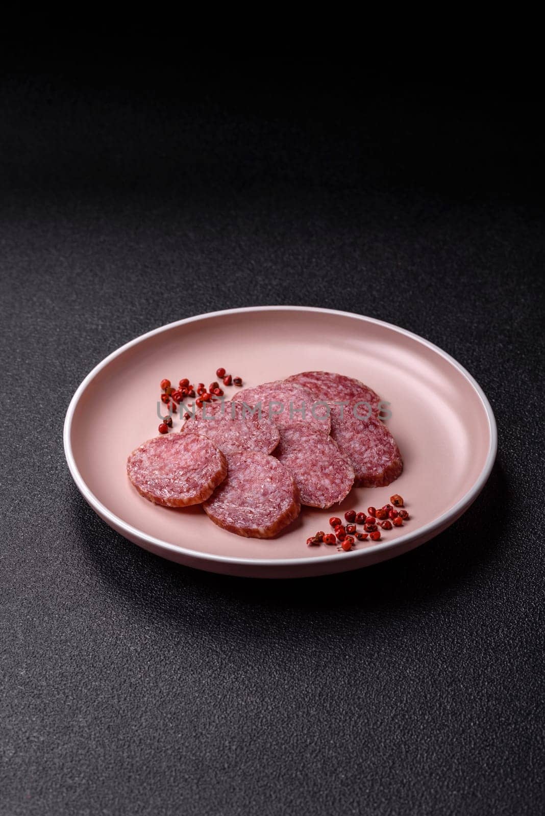 Sliced salami sausage, smoked meat, delicious deli snacks on a plate
