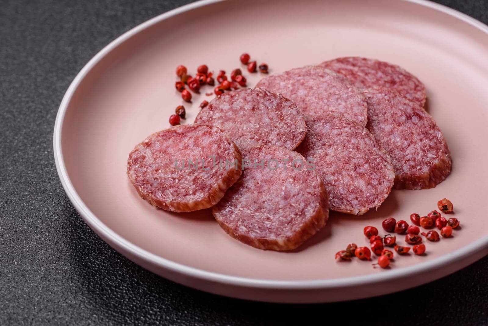 Sliced salami sausage, smoked meat, delicious deli snacks on a plate