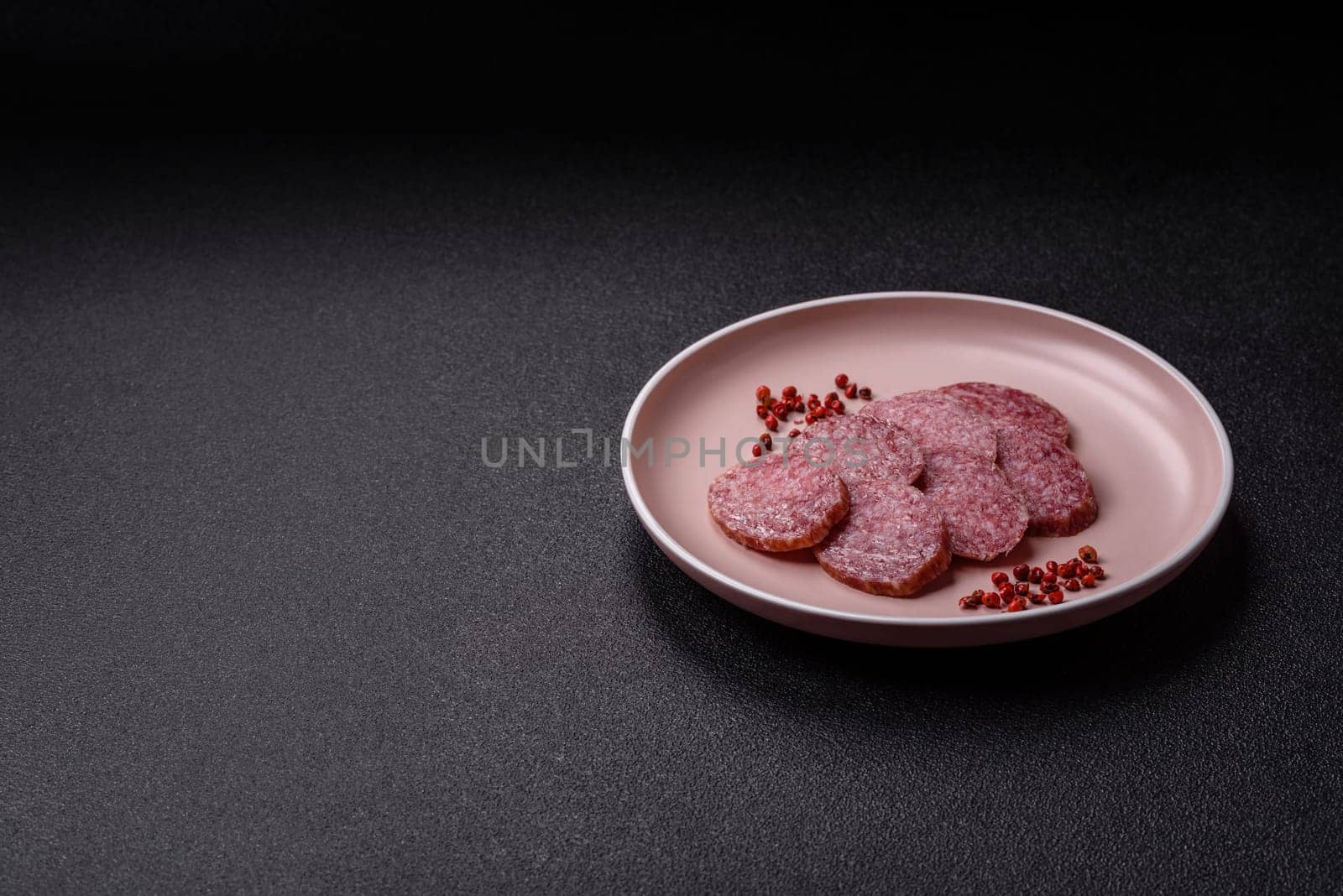 Sliced salami sausage, smoked meat, delicious deli snacks on a plate