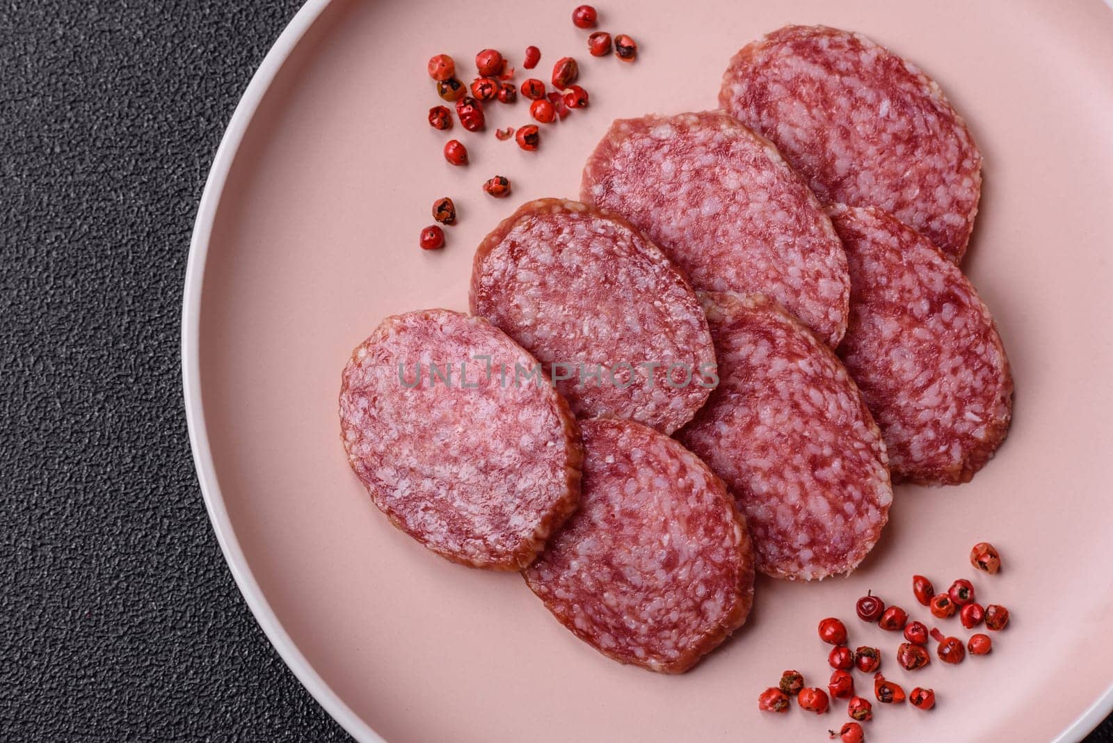 Sliced salami sausage, smoked meat, delicious deli snacks on a plate