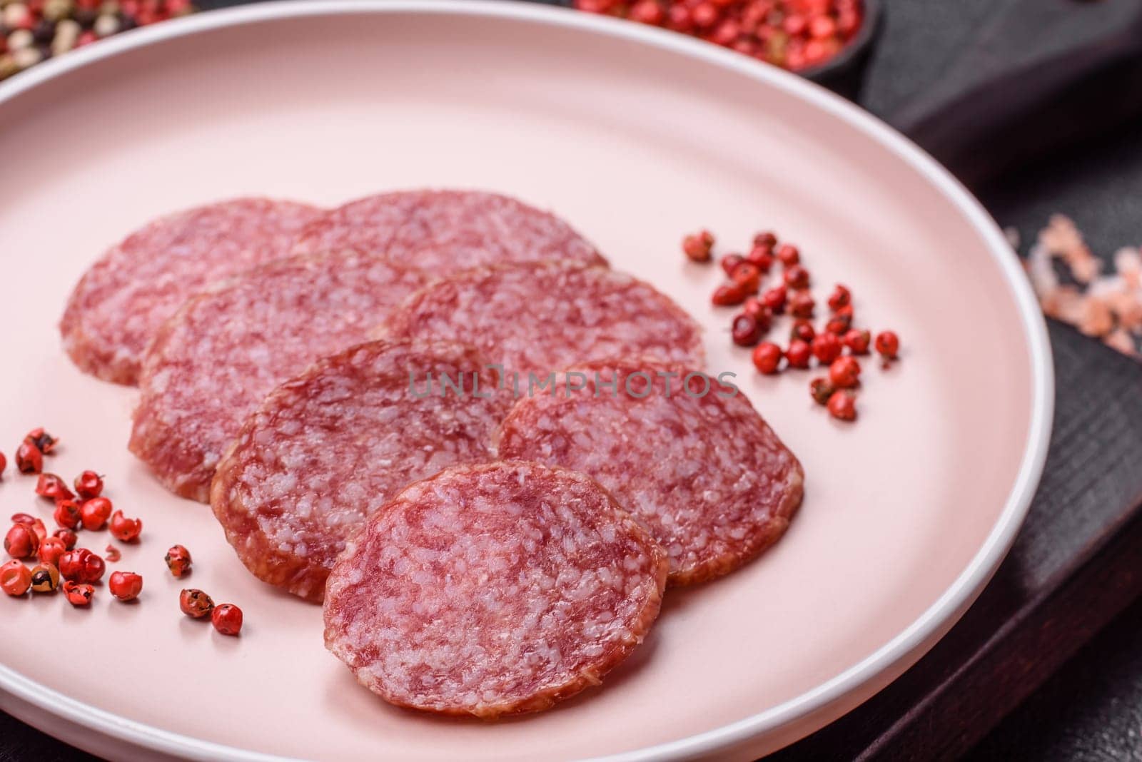 Sliced salami sausage, smoked meat, delicious deli snacks on a plate
