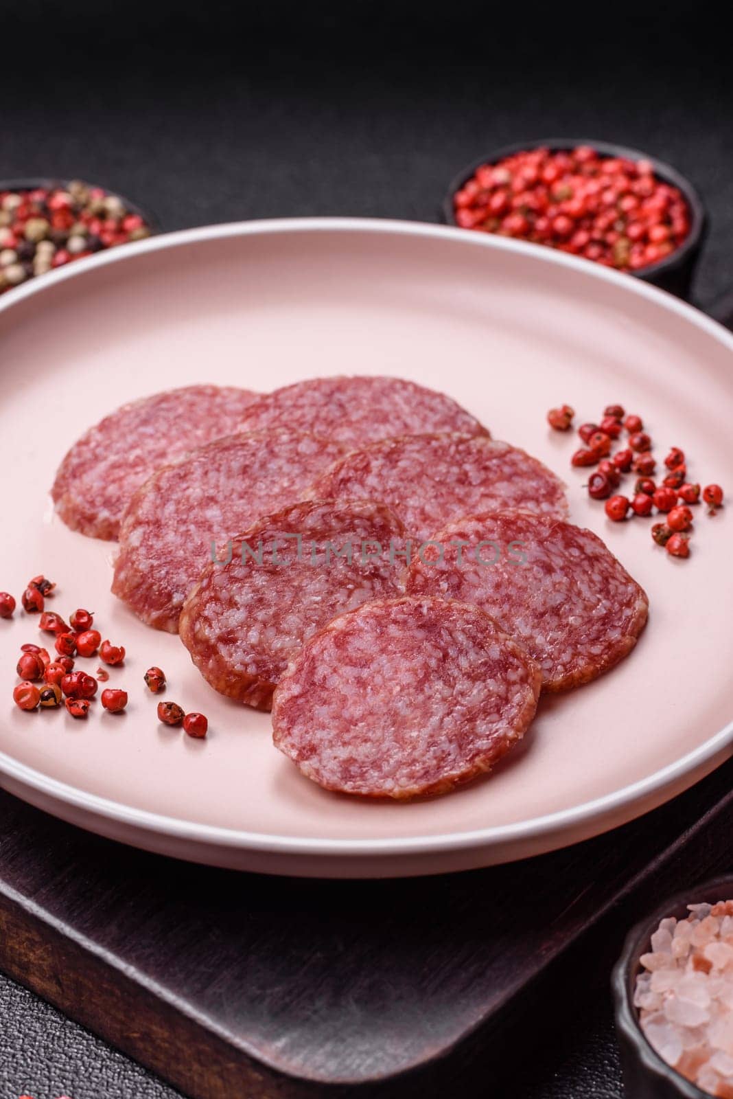Sliced salami sausage, smoked meat, delicious deli snacks on a plate