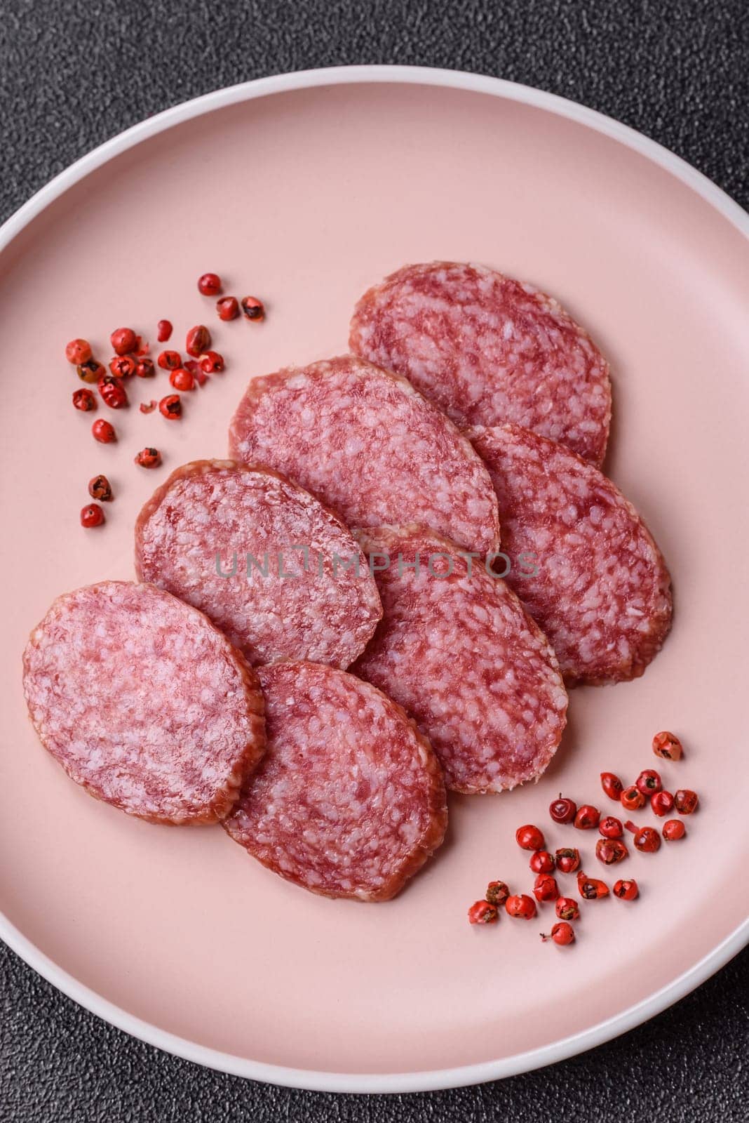 Sliced salami sausage, smoked meat, delicious deli snacks on a plate