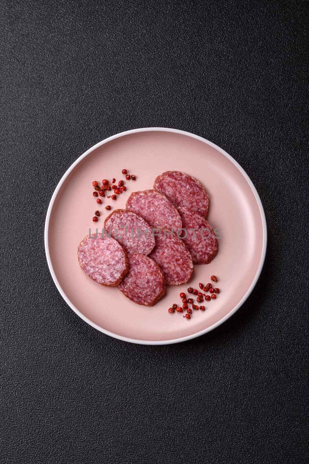 Sliced salami sausage, smoked meat, delicious deli snacks on a plate