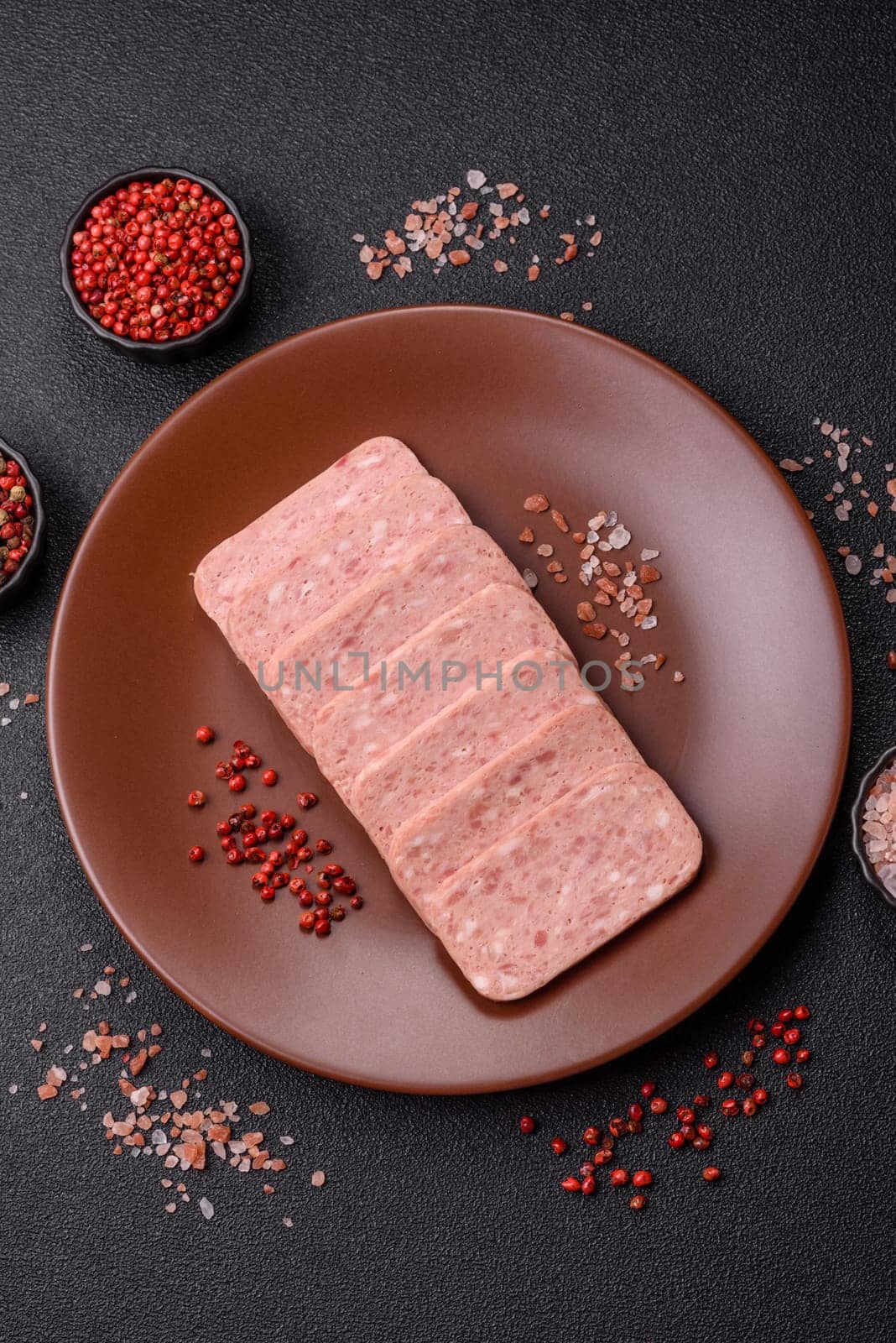 Canned ham, meat, pork, with spices and salt, slices on a dark concrete background