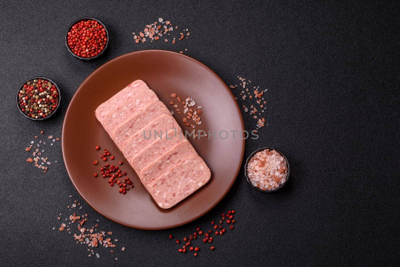 Canned ham, meat, pork, with spices and salt, slices on a dark concrete background