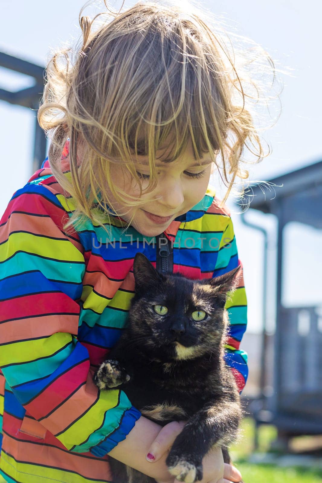 Child hugging a cat on the street. Selective focus. kid.