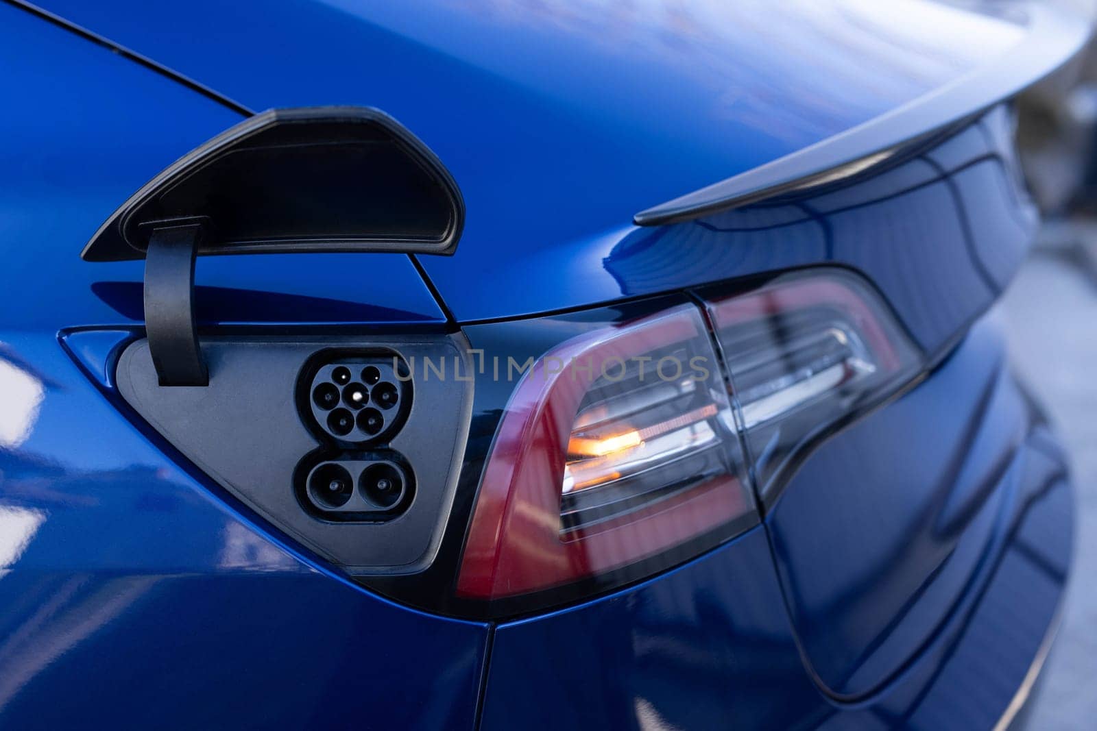 Type 2 CCS plug port on electric vehicle. DC - CCS type 2 EV charging connector at EV car. Fast charging socket type 2 combo electric car. Eco friendly alternative energy green environment concept