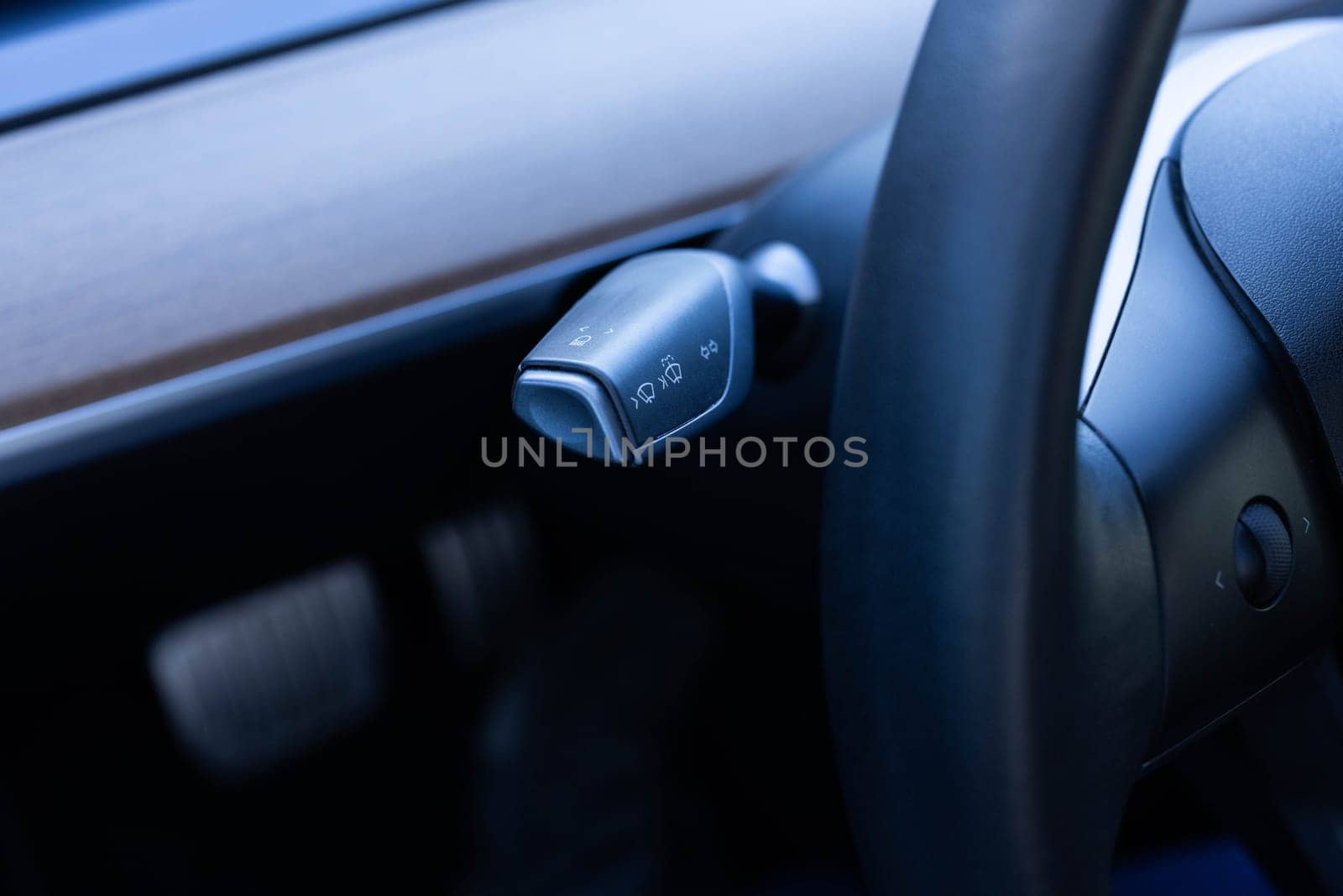 Detail of turning signal, headlights controller in modern car. Multifunction Headlight Console Control Switch knob of electric car. Handle with buttons windshield wiper, turn signal, and washer in car