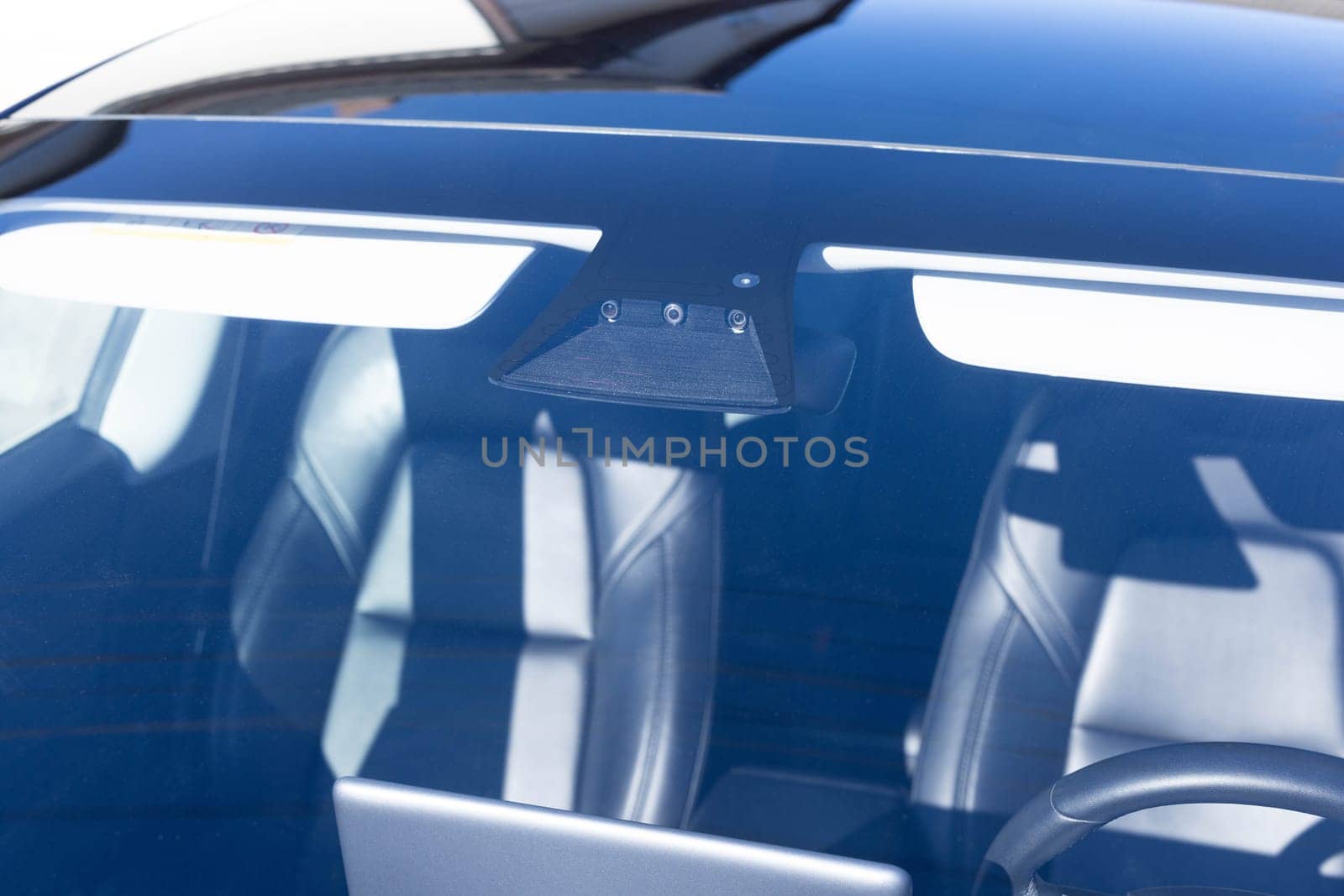 Rain and light sensor on the windshield of the car. Close up view of modern driver assistance. Car System Intelligence - Surround View 360 Degrees Bird Eye View, Line Assist, Front Camera.