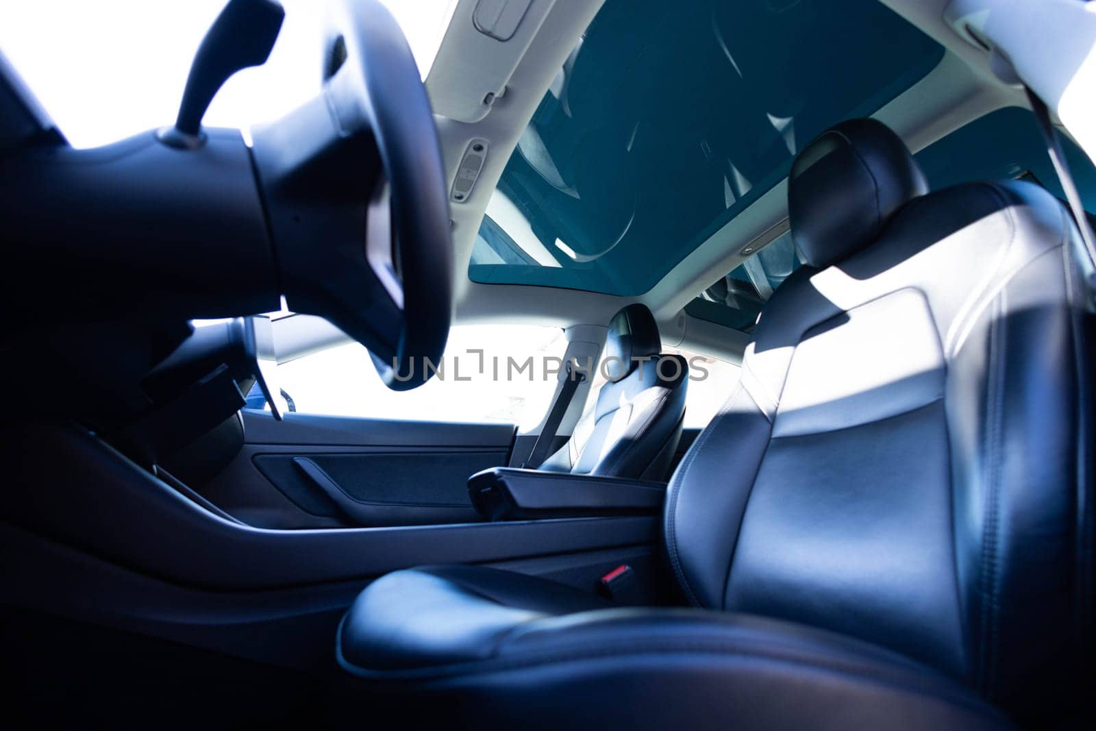 Panoramic glass sun roof in the new electric car. Clean glass and view from inside to the sky. Sunroof hatch with tinted glass. Automotive sunroof. Hatch in car roof.