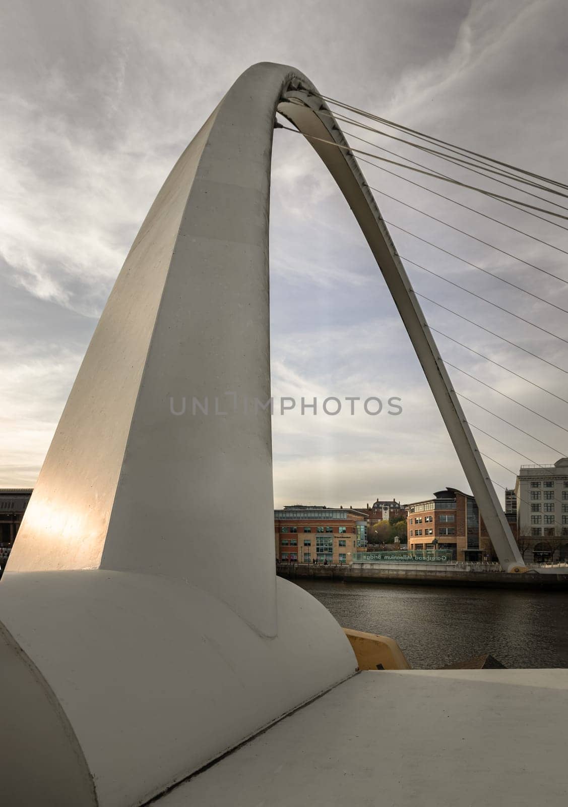Newcastle, UK - Apr 11, 2025 - Perspective of The Iconic gateshead millennium bridge spanning the River Tyne with ancient buildings and sky in the background before sunset in Newcastle Upon Tyne in the North East of England. The pedestrian bridge, use it as your Wallpaper, Poster and Space for text, Selective focus.