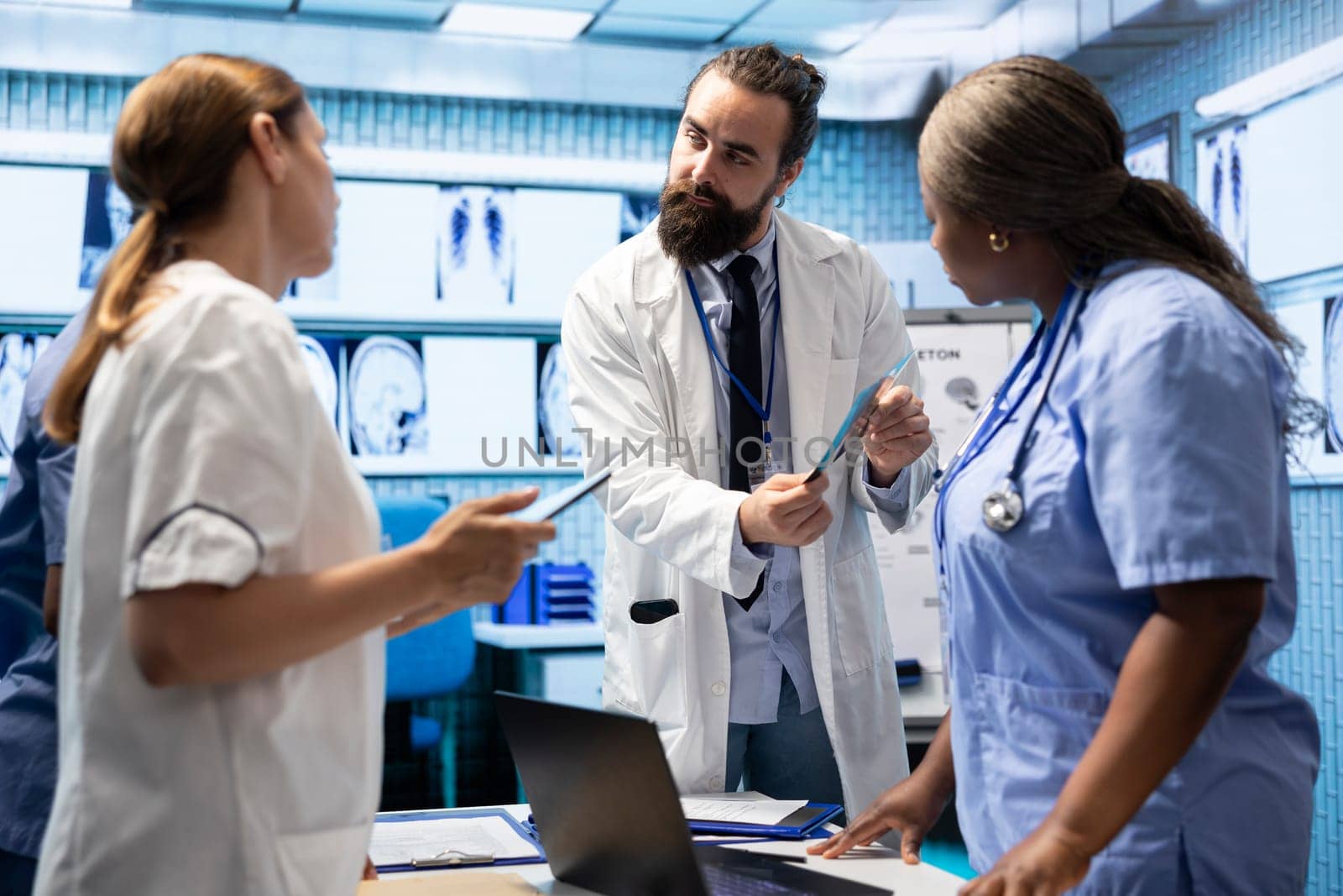 Radiologists and doctors analyze x rays and discuss patient care in a medical office. Team of skilled healthcare specialists working together to provide accurate diagnosis and treatment plans.