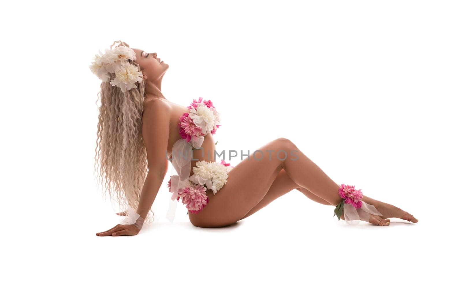 Full body side view of sensual young female in white white floral lingerie against white background