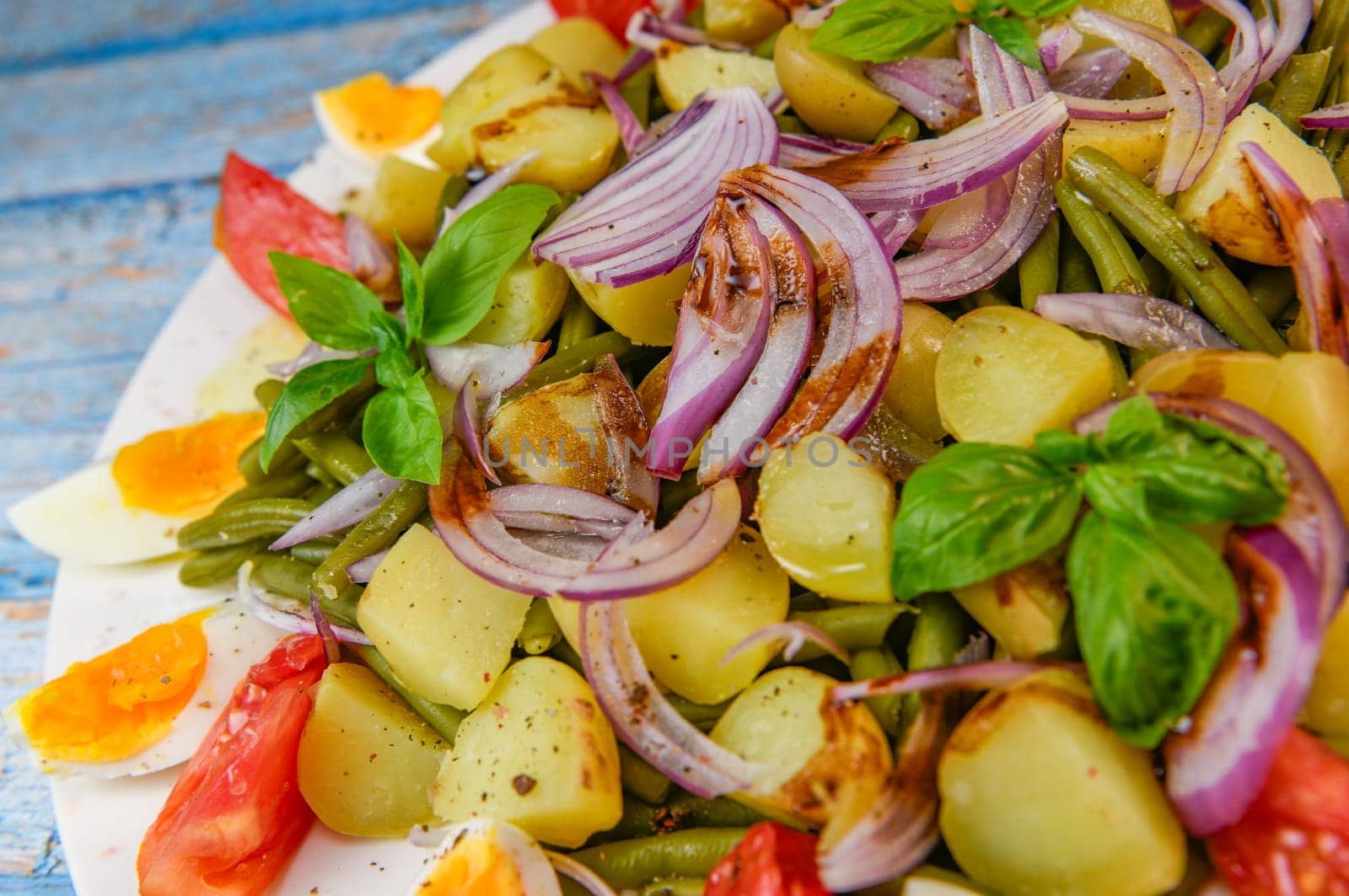 Fresh salad, green beans, small potatoes, egg, tomato, basil, red onions and balsamic vinaigrette. High quality photo