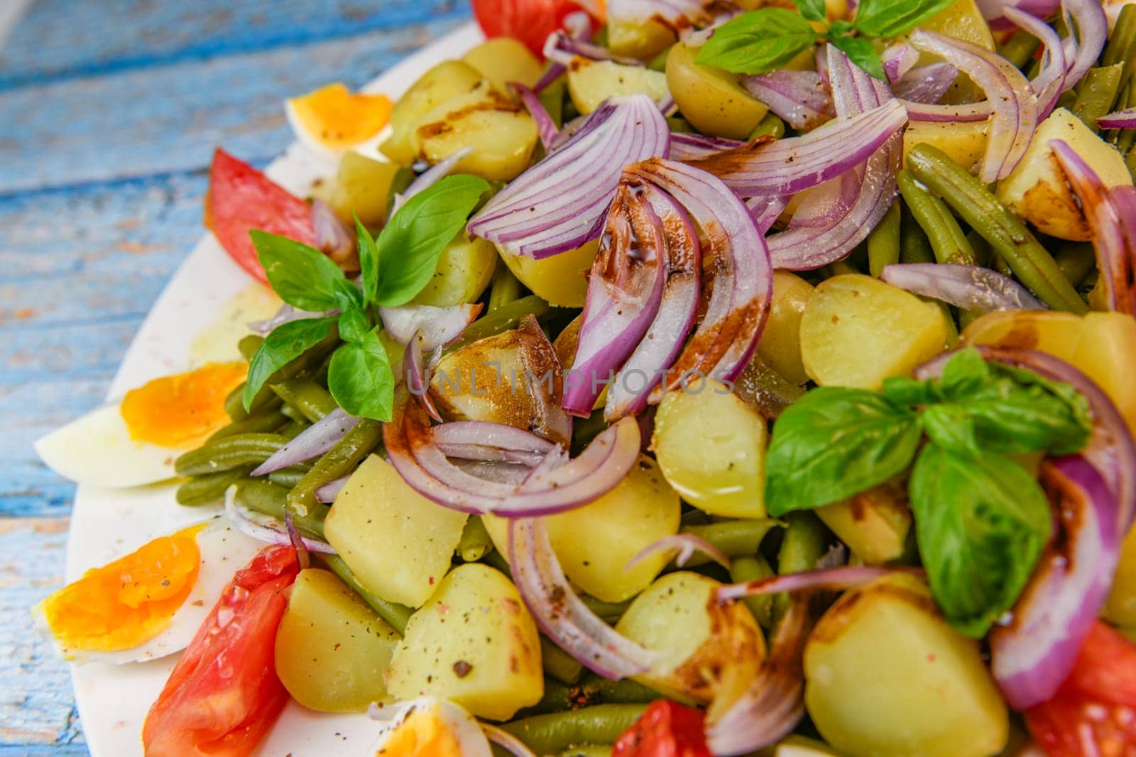 Fresh salad, green beans, small potatoes, egg, tomato, basil, red onions and balsamic vinaigrette. High quality photo