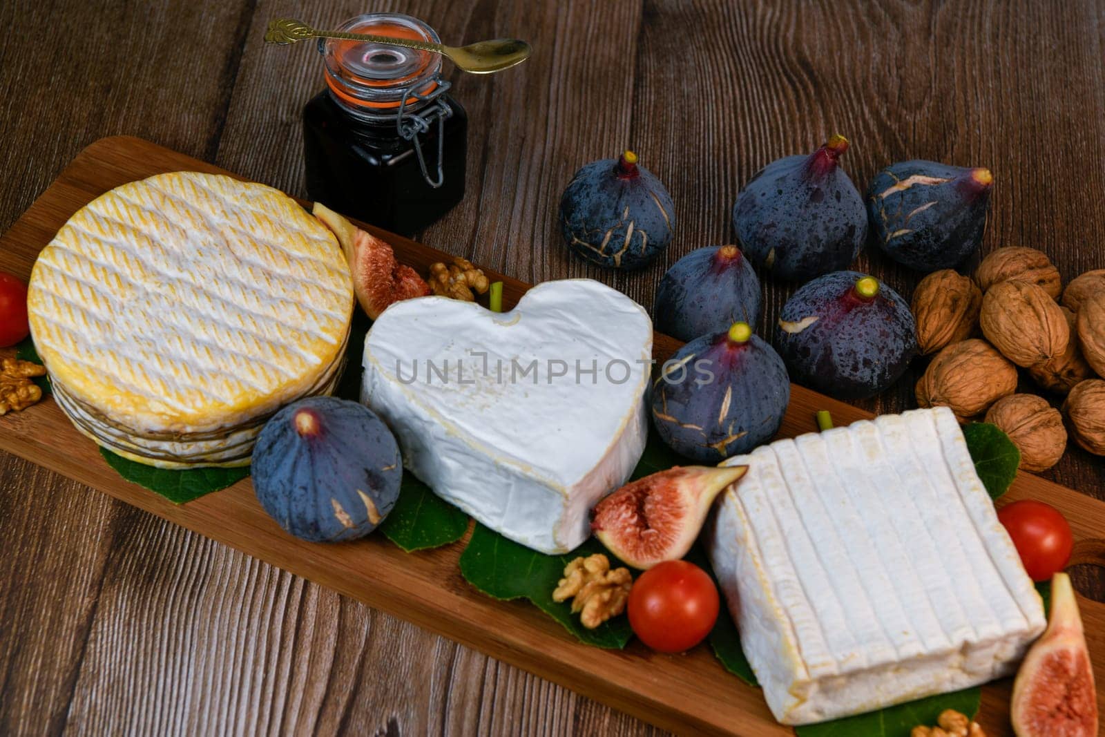 Selection of French cheeses from Normandy, AOP, Livarot, Neufchatel, Pont l'eveque, Rye bread, figs, walnuts, grapes, elderberry gelee. High quality photo
