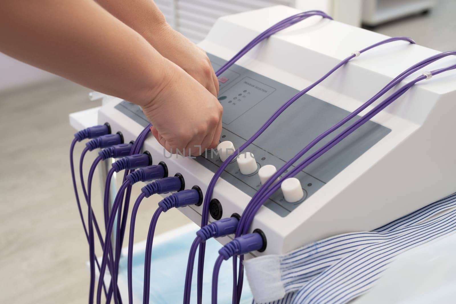 High angle of crop anonymous doctor preparing machine for anti cellulite massage