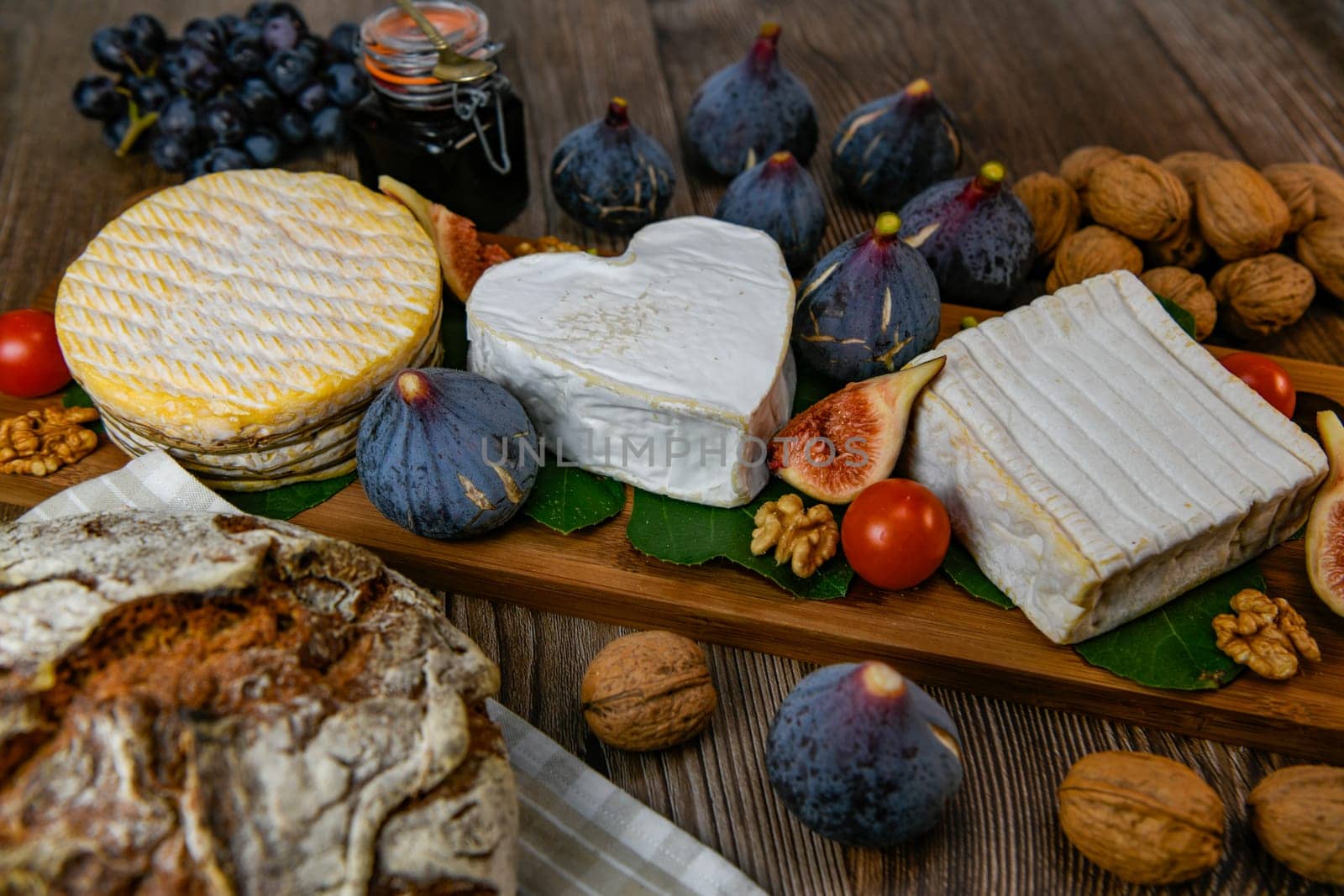 Selection of French cheeses from Normandy, AOP, Livarot, Neufchatel, Pont l'eveque, Rye bread, figs, walnuts, grapes, elderberry gelee. High quality photo