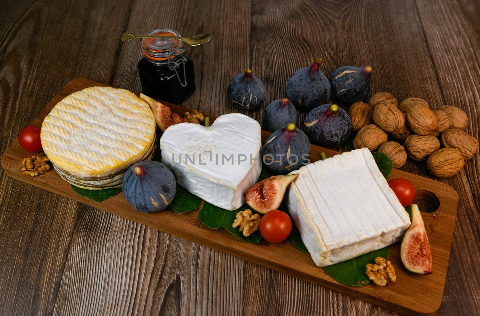 Selection of French cheeses from Normandy, AOP, Livarot, Neufchatel, Pont l'eveque, Rye bread, figs, walnuts, grapes, elderberry gelee. High quality photo