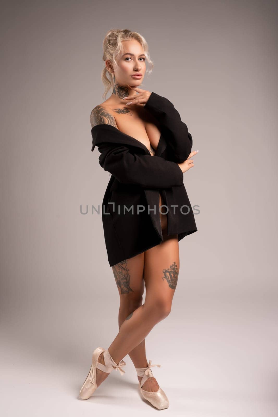 Stylish blonde tattowed woman in black cloth