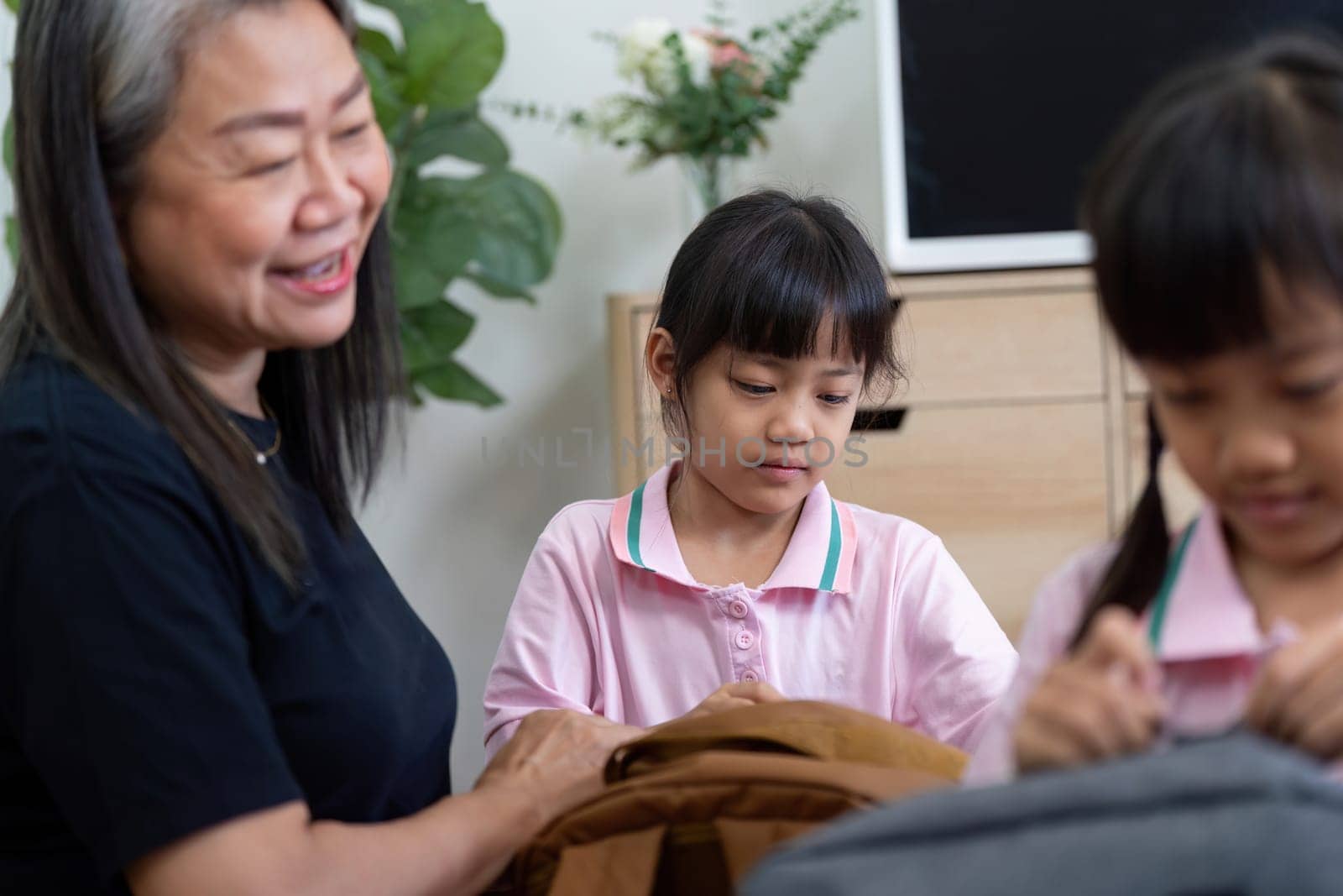 A warm moment as an adult helps children prepare their school bags, emphasizing the importance of family in the educational journey.