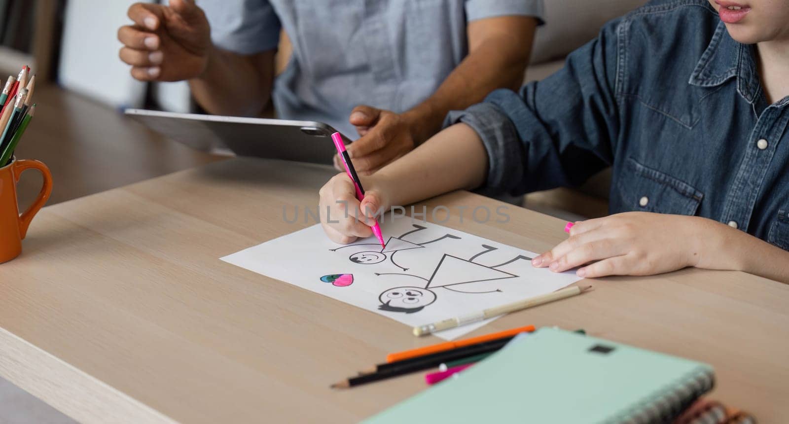 A grandfather helps his grandson with drawing, providing guidance and support in a nurturing environment, illustrating the importance of family connection through creative activities.