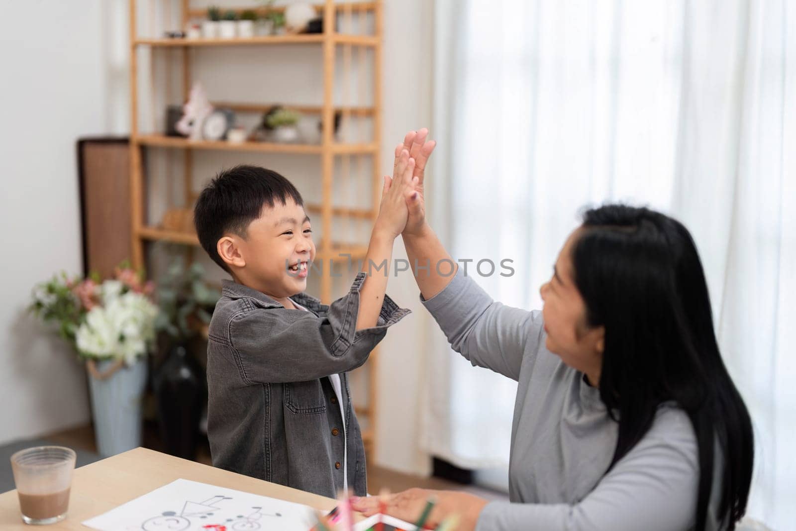 A mother and her son celebrate a successful school preparation with high-fives, showcasing the fun and excitement of getting ready for school.
