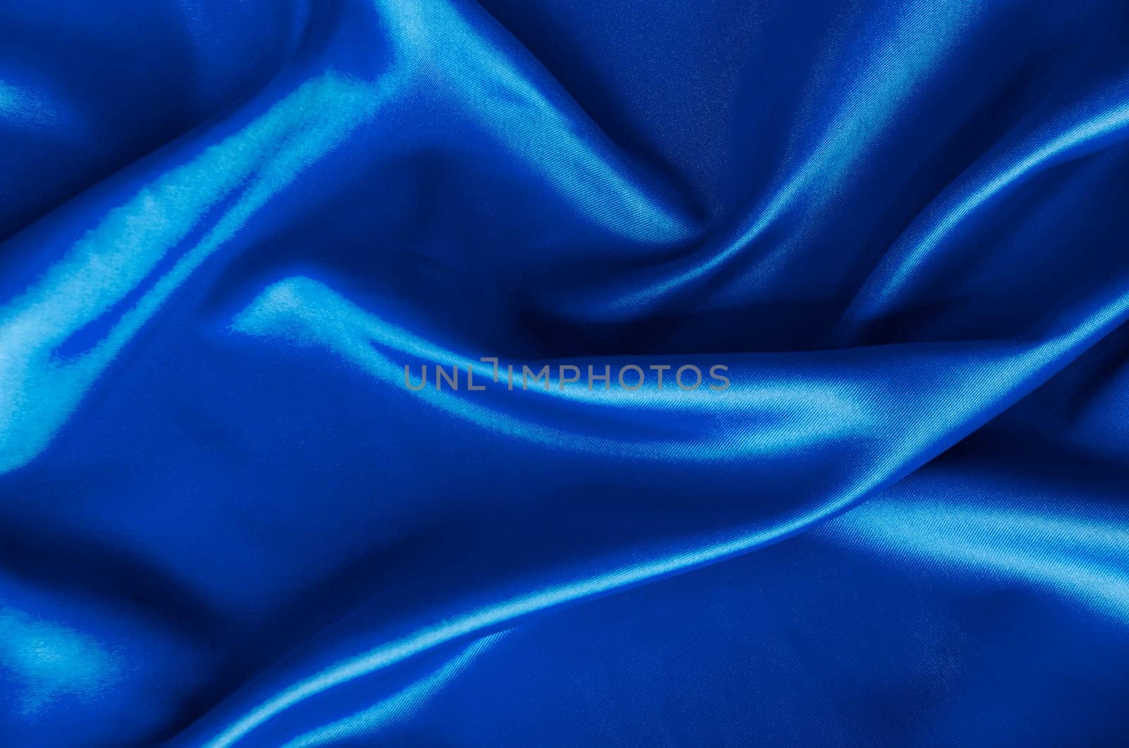 Polished blue silk cloth with silky sheen and beautiful natural draping. Suitable for design and wallpaper background.
