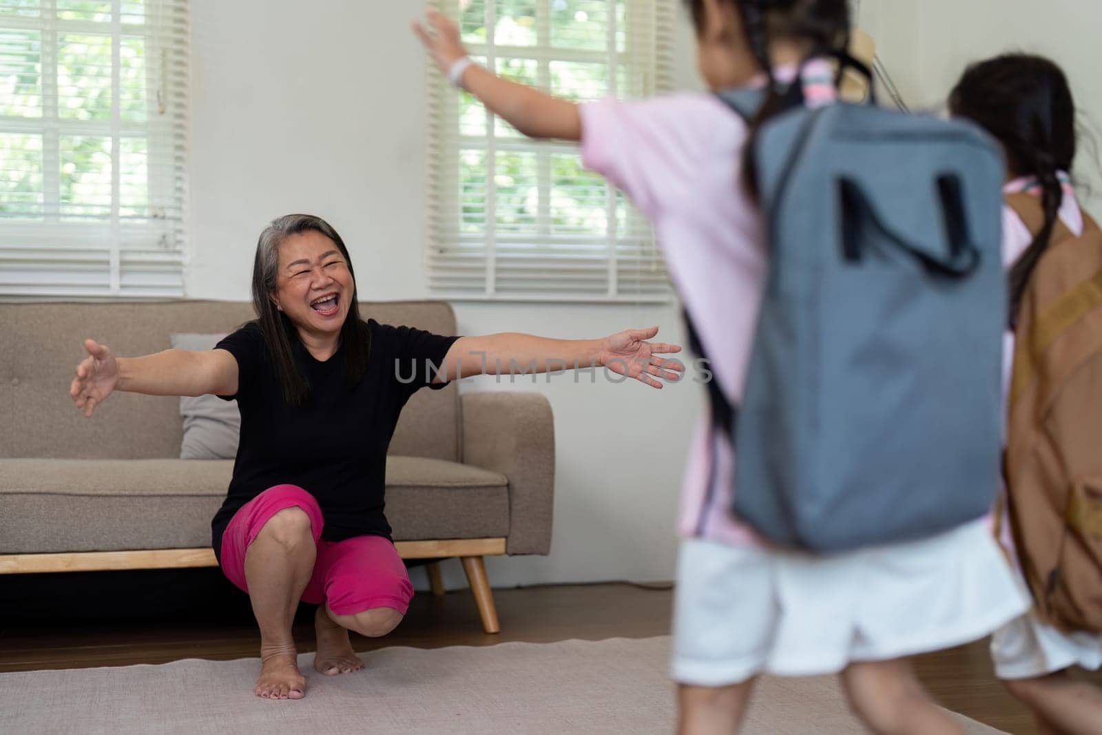 A joyful mother opens her arms wide to welcome her children back from school, celebrating their return with love and excitement. This moment emphasizes family bonds.