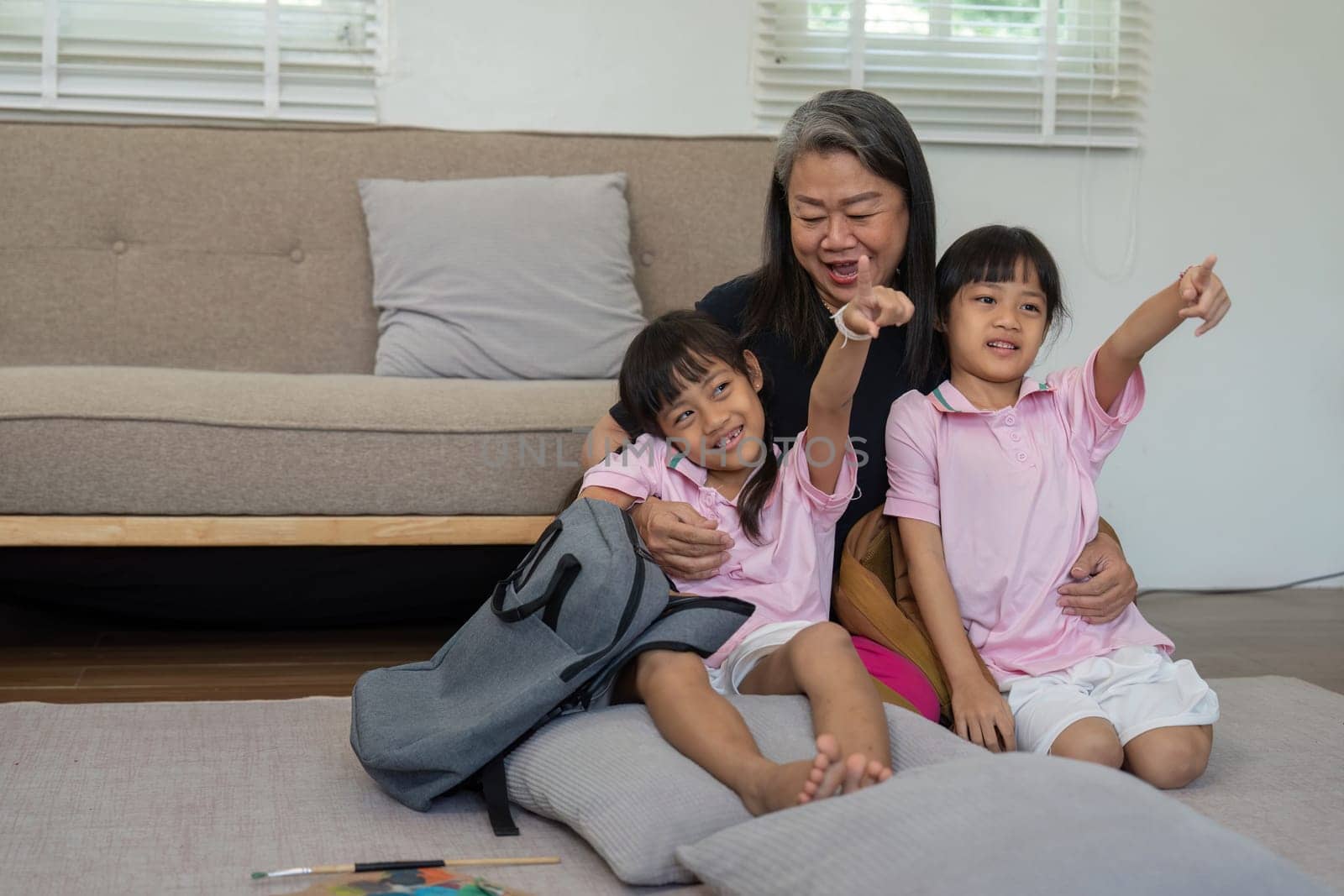 Two young girls enjoy a joyful moment with their grandmother, highlighting the importance of family bonds and shared experiences.