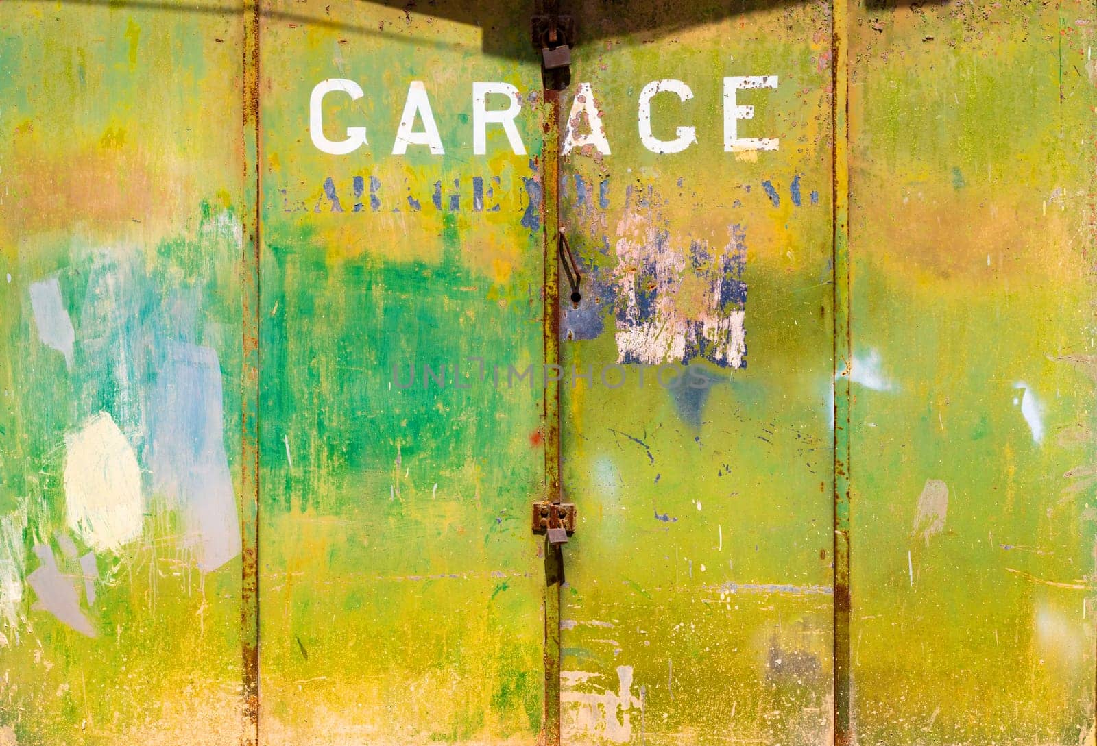 Old rusty green metal garage gate with a lock on it