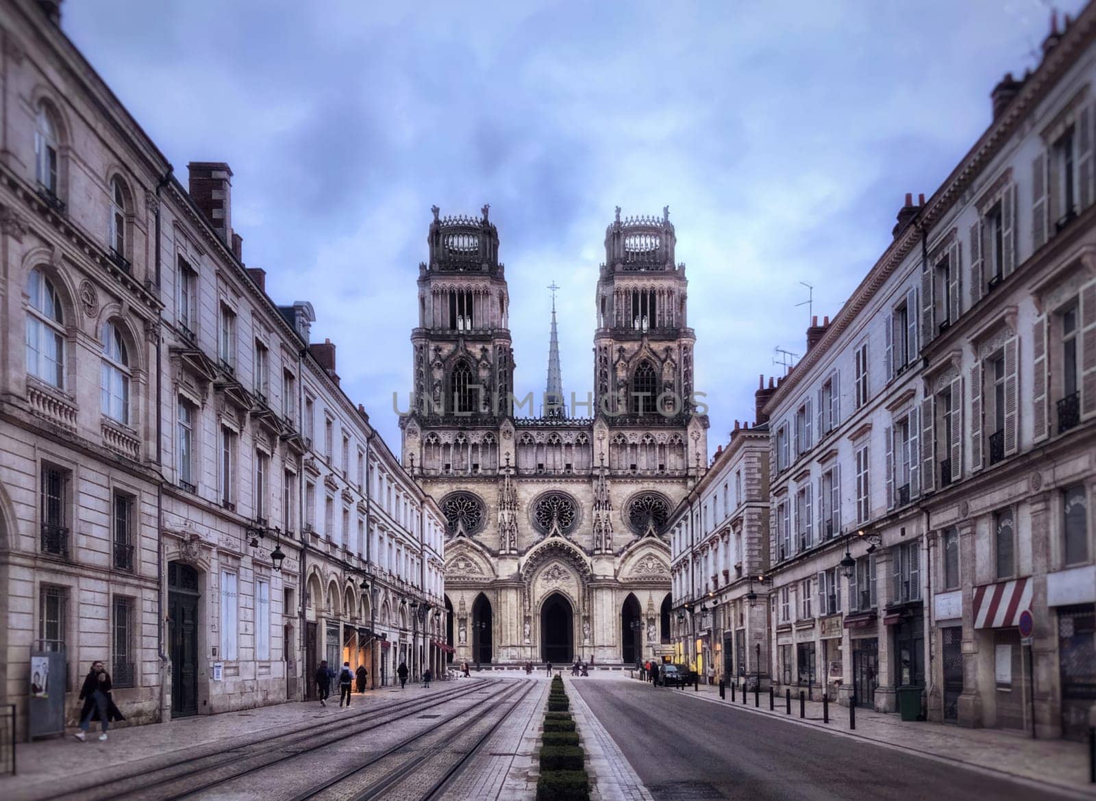 Orleans, France - May 25, 2024: The Cathedral church of Orleans , picturing its facade and the street with buildings