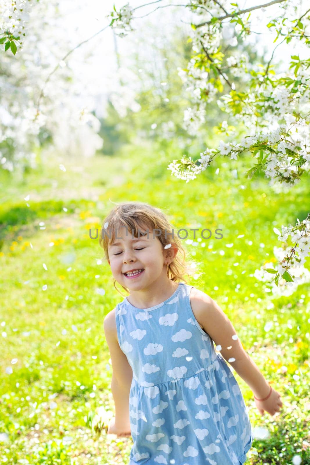 Child in a garden of flowering trees. Selective focus. kid.