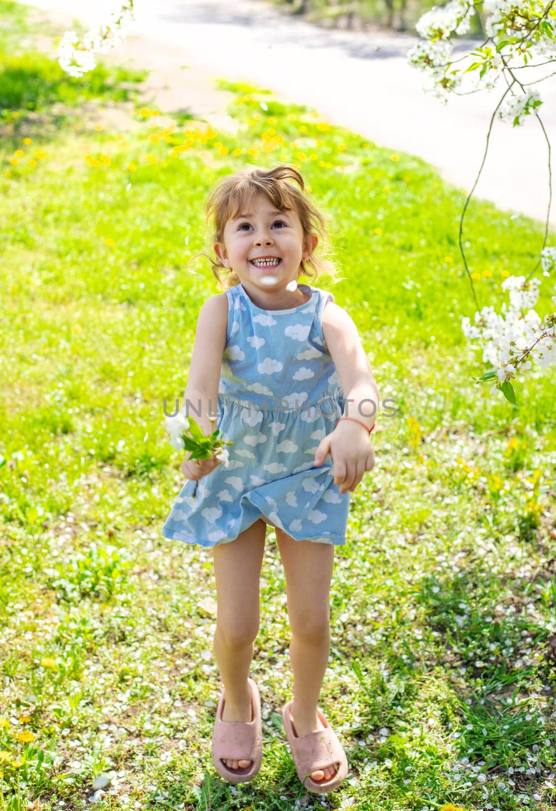 Child in a garden of flowering trees. Selective focus. kid.