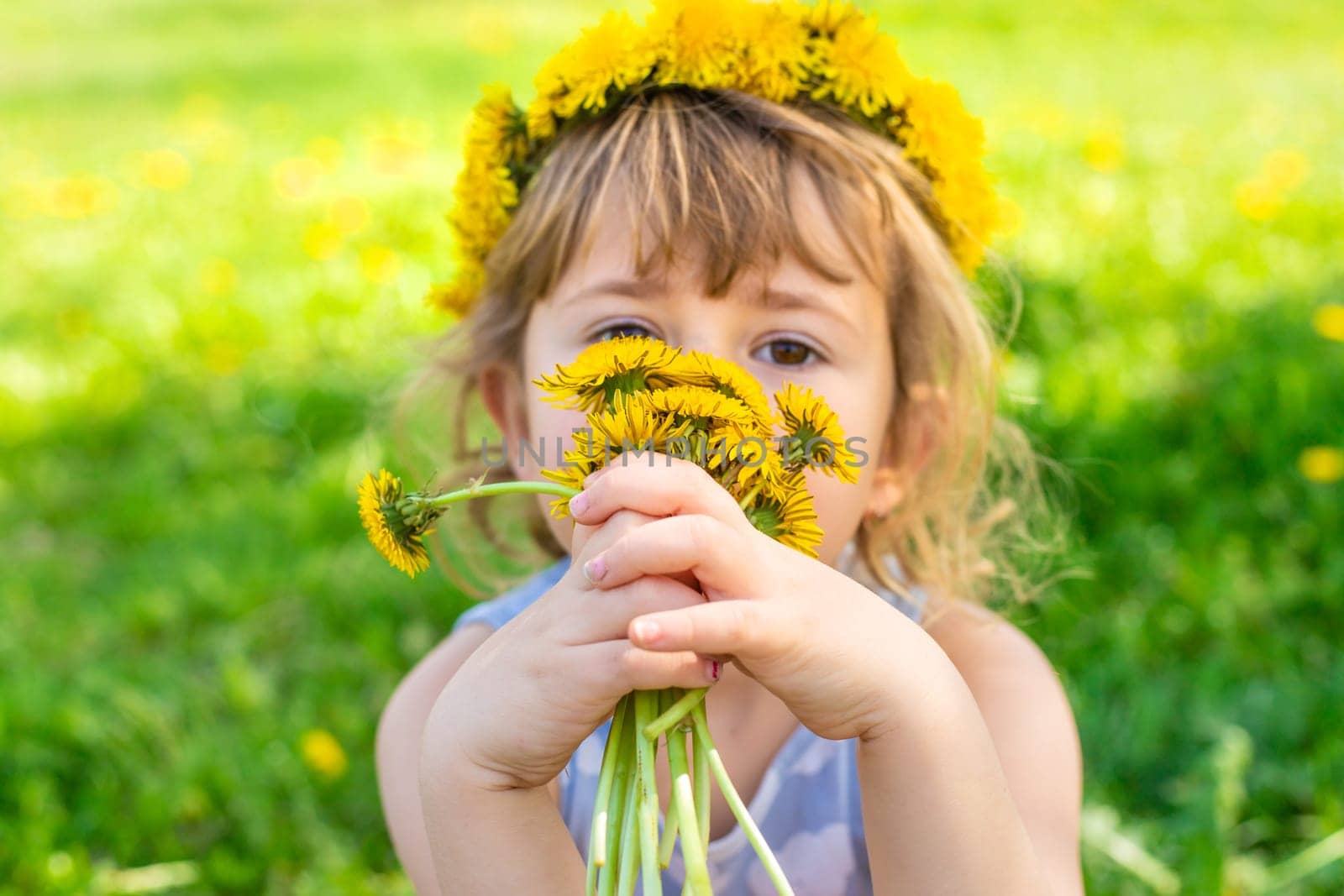 Child in the garden with a bouquet of dandelions. Selective focus. Kid.