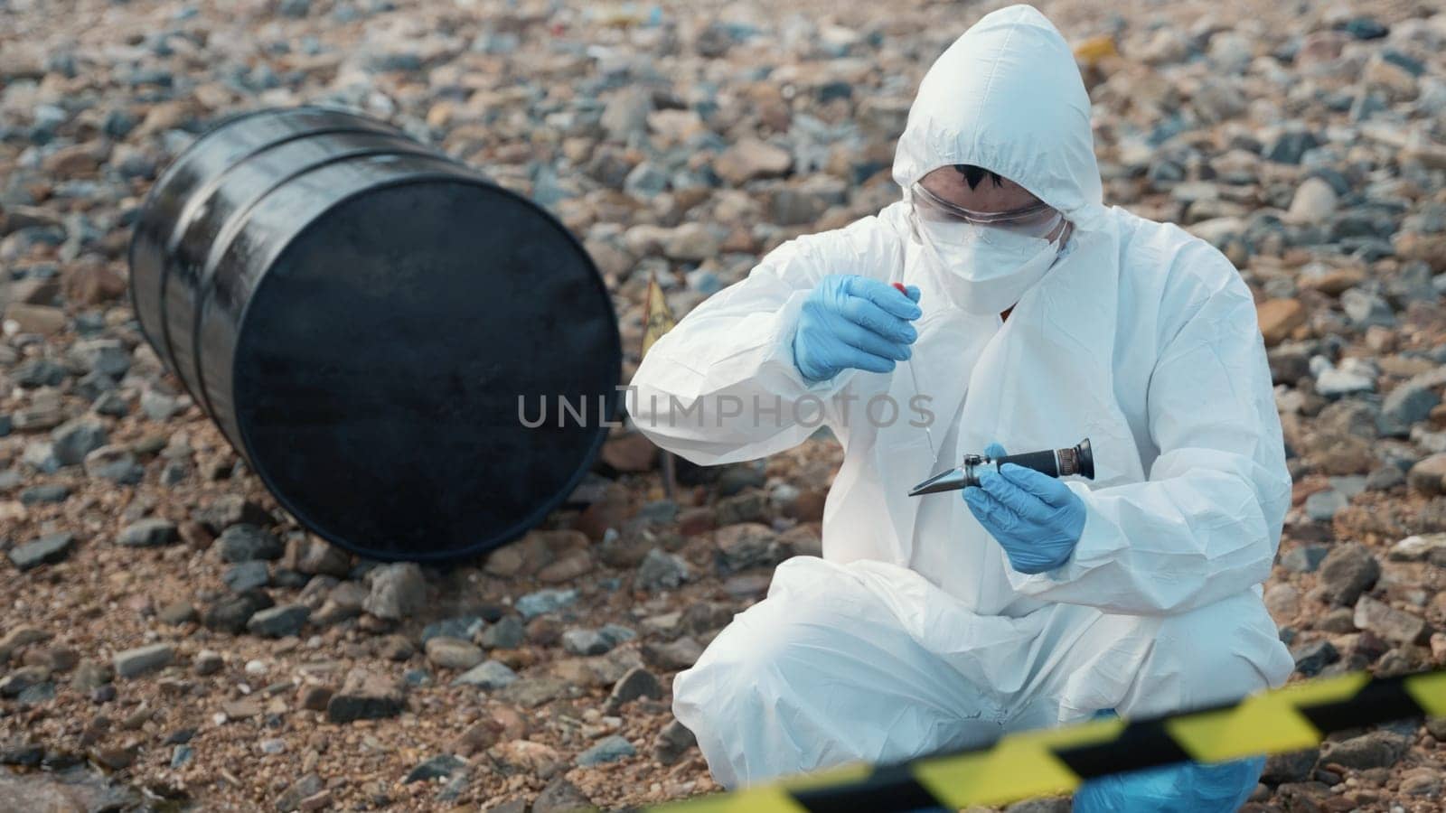 Ecologist sampling water from the river to water quality tester and peek into, Biologist wear protective suit and mask collects sample of waste water from industrial for pH meter, problem environment