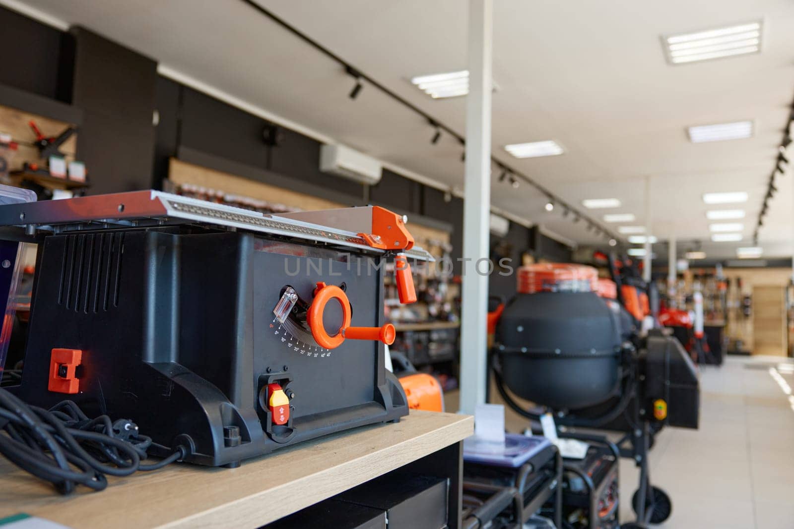 Modern table saw display at professional hardware store offering woodwork tools wide assortment. Carpentry shop with equipment for workplace organization