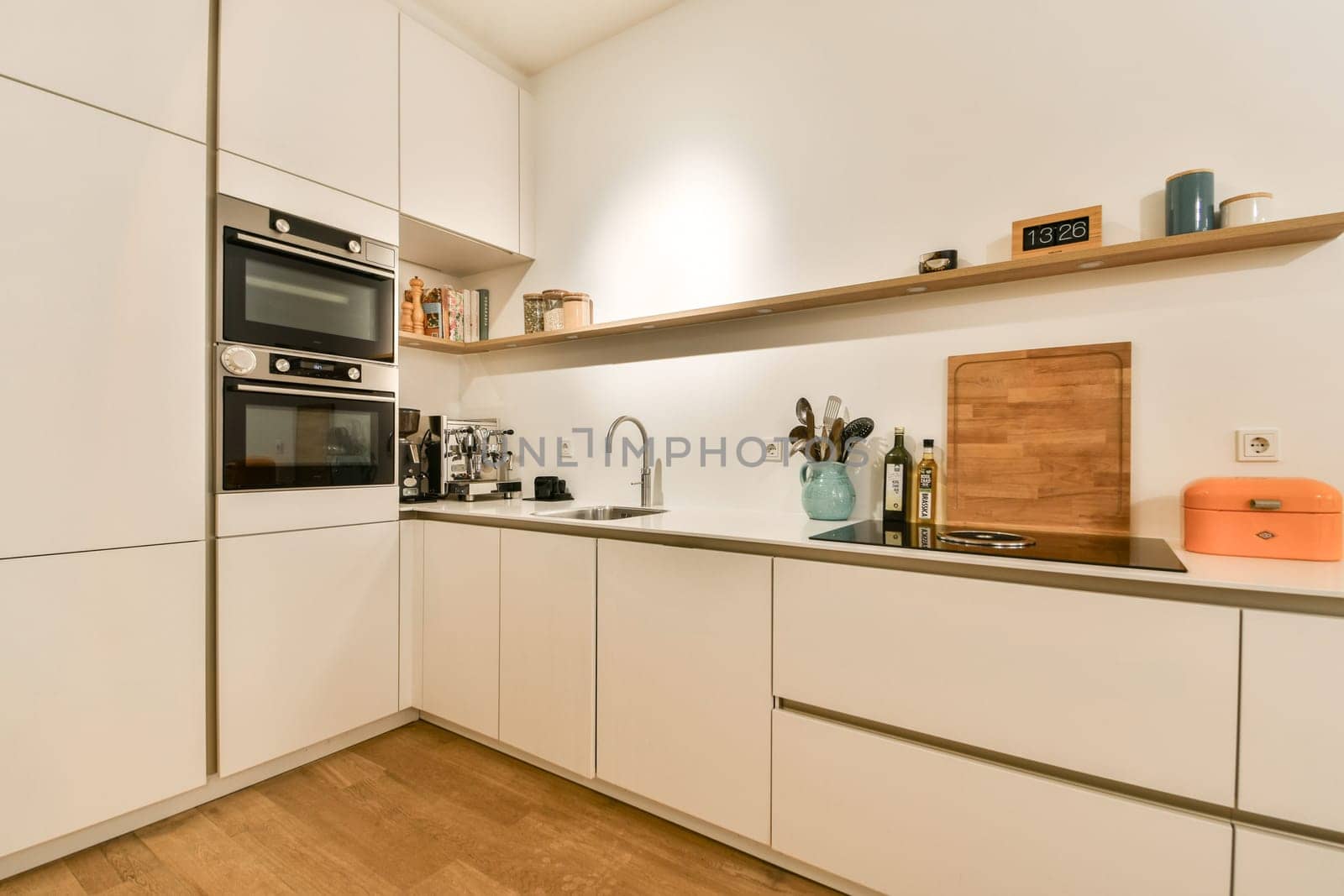 A sleek and contemporary kitchen featuring minimalist cabinetry, modern appliances, and warm wooden accents. Ideal for cooking and social gatherings.