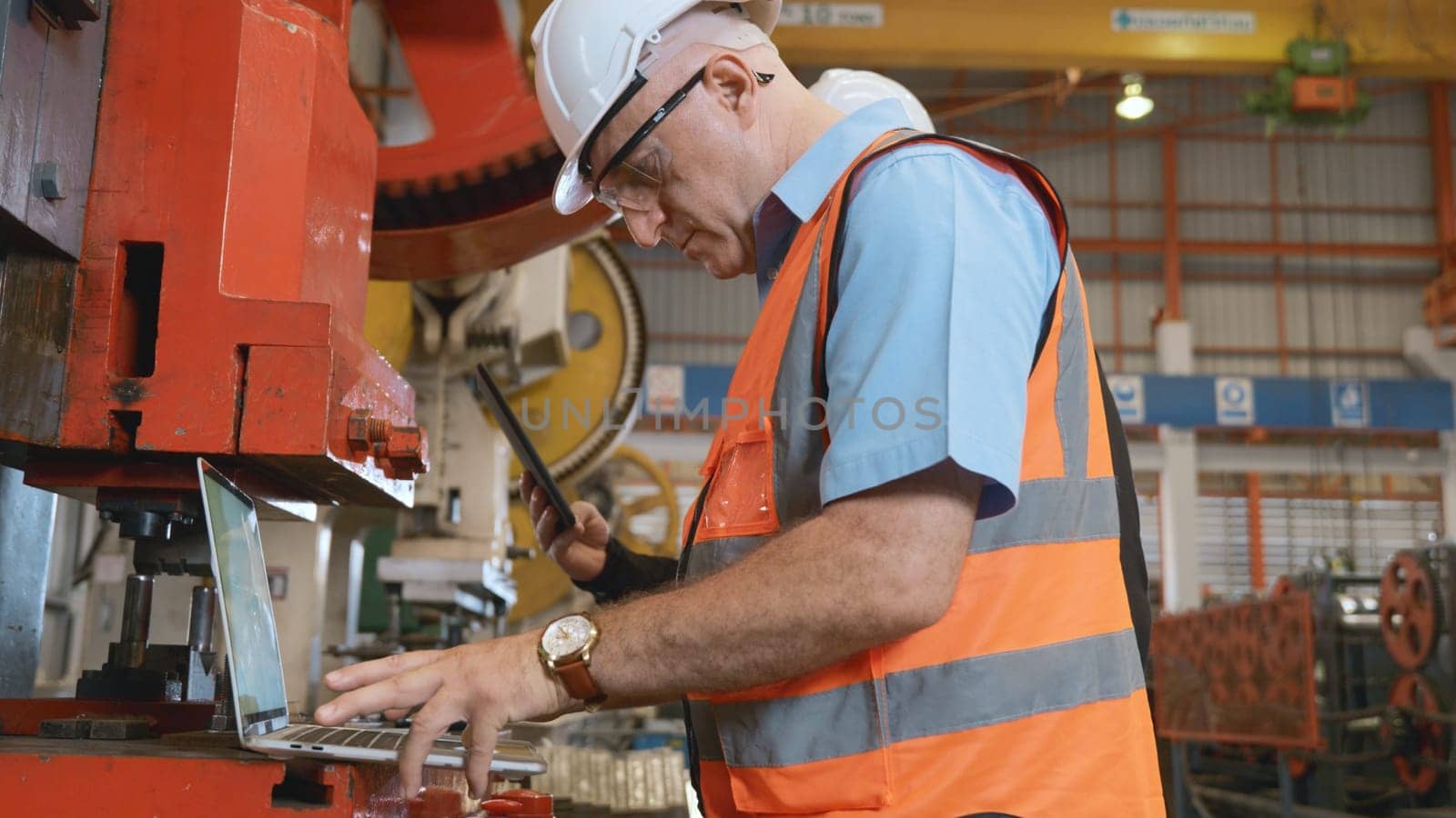 Factory worker using a laptop with an engineering software, Engineer using laptop computer controlling program for maintenance automatic to metal sheet stamping machine, industry programer man