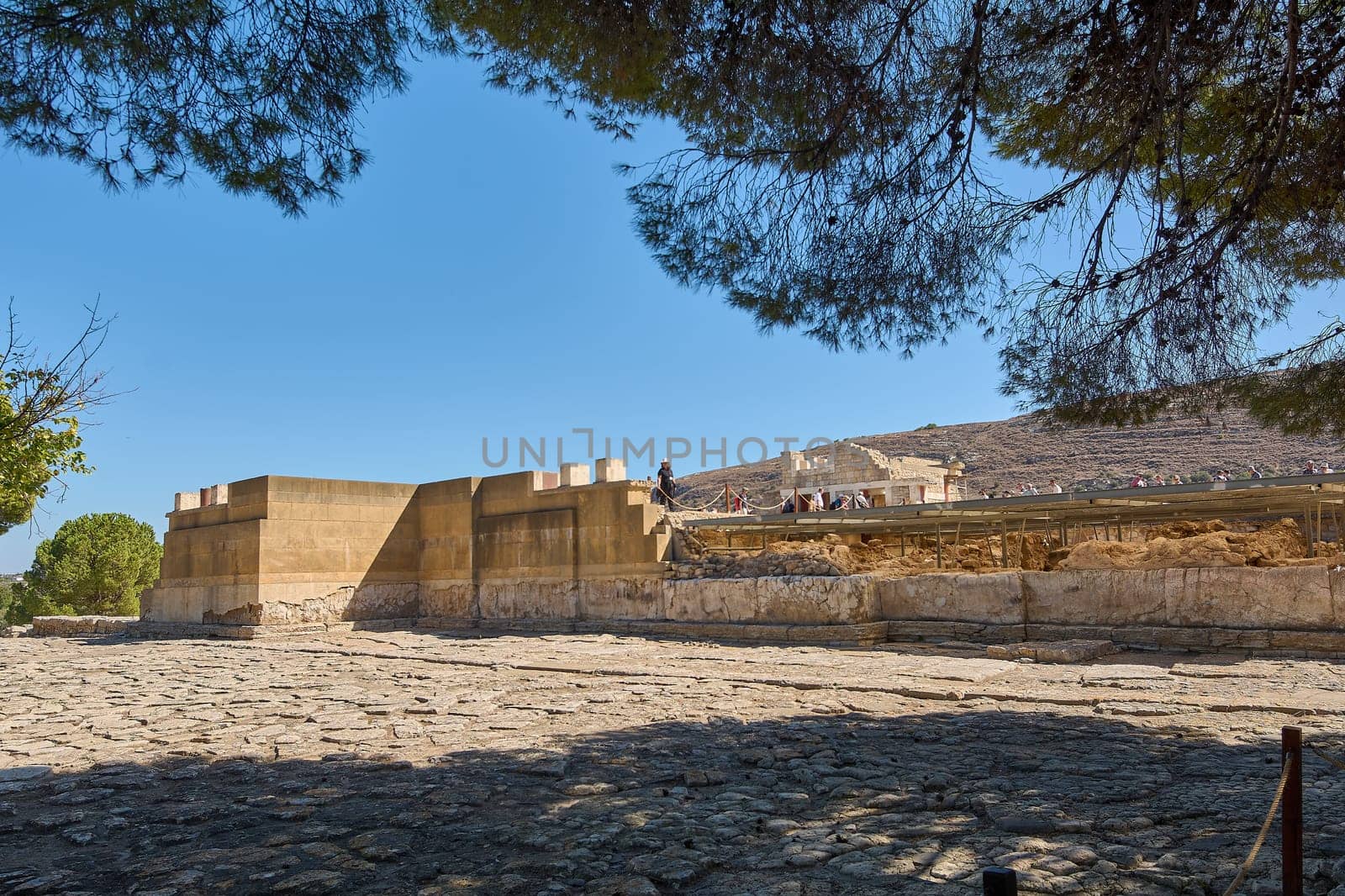 Crete.Greece - april 24, 2025: The historic site of Knossos, featuring its ancient ruins and reconstructed columns. The bright sunlight highlights the architectural details of this Minoan civilization